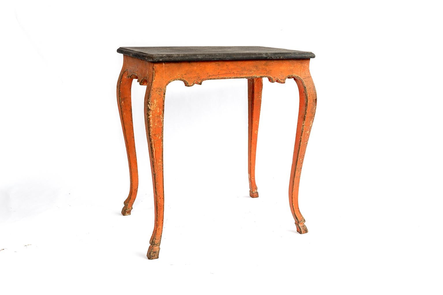 A salmon painted side table with a ebonized painted top.
 