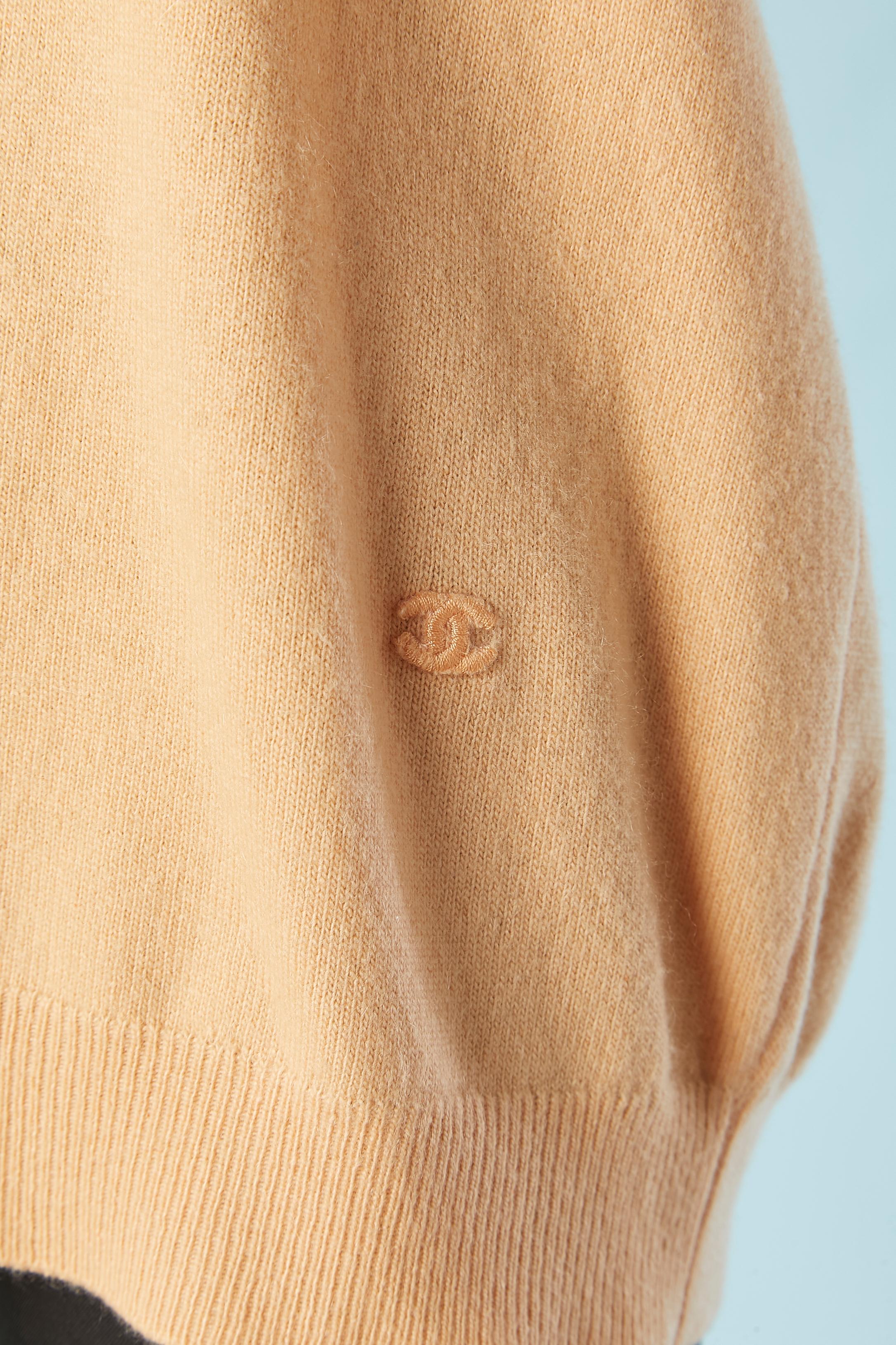Salmon pink cashmere sweater with short sleeves. One branded button on the top middle back. One tiny tone on to ne 