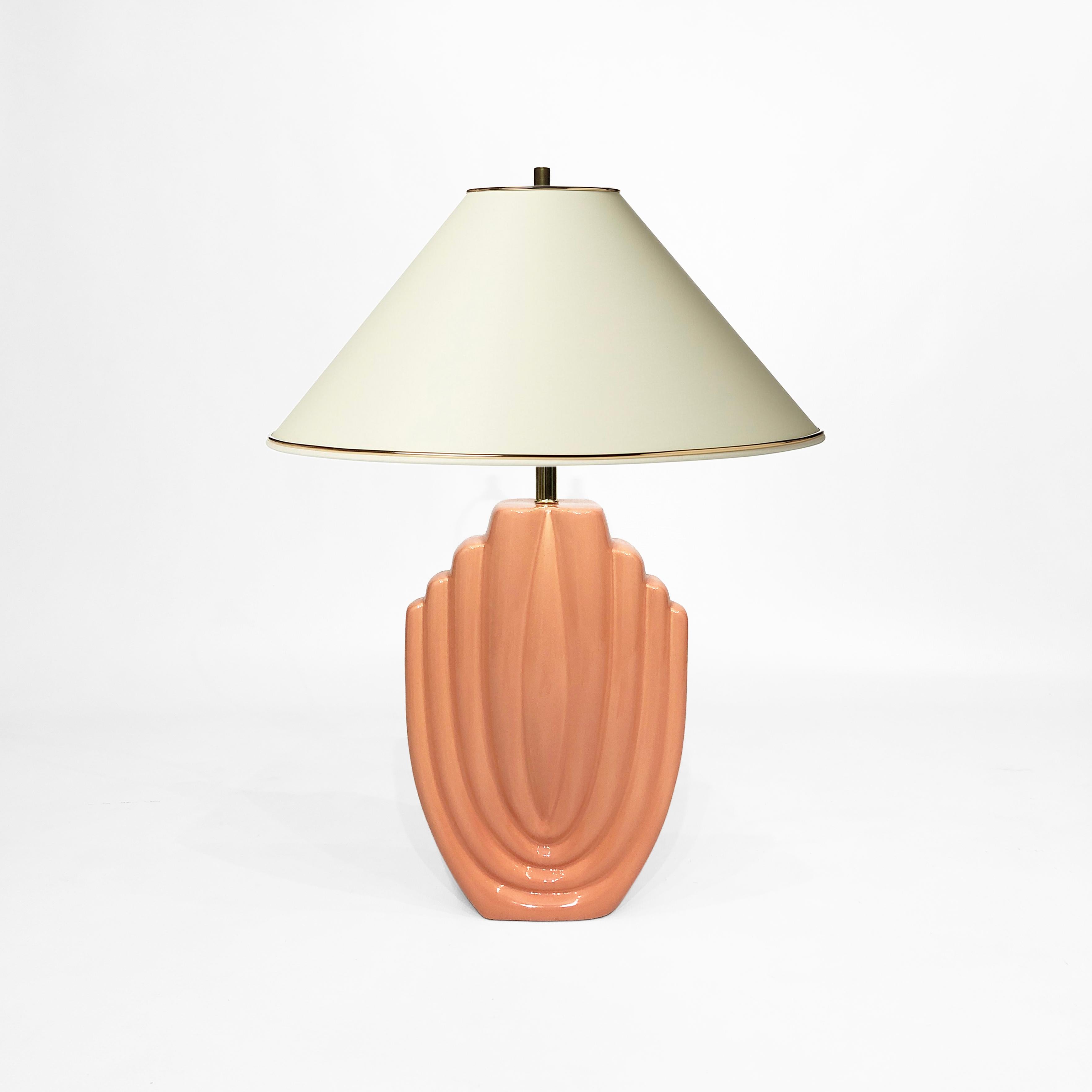 A tall salmon-coloured table lamp, with shades of the Art Deco style, in a wonderful textured ceramic. The nod to the Golden Girls-era 1980s; elegant shell-like pattern; and pastel colouring of the lamp body means it would look perfect in interiors