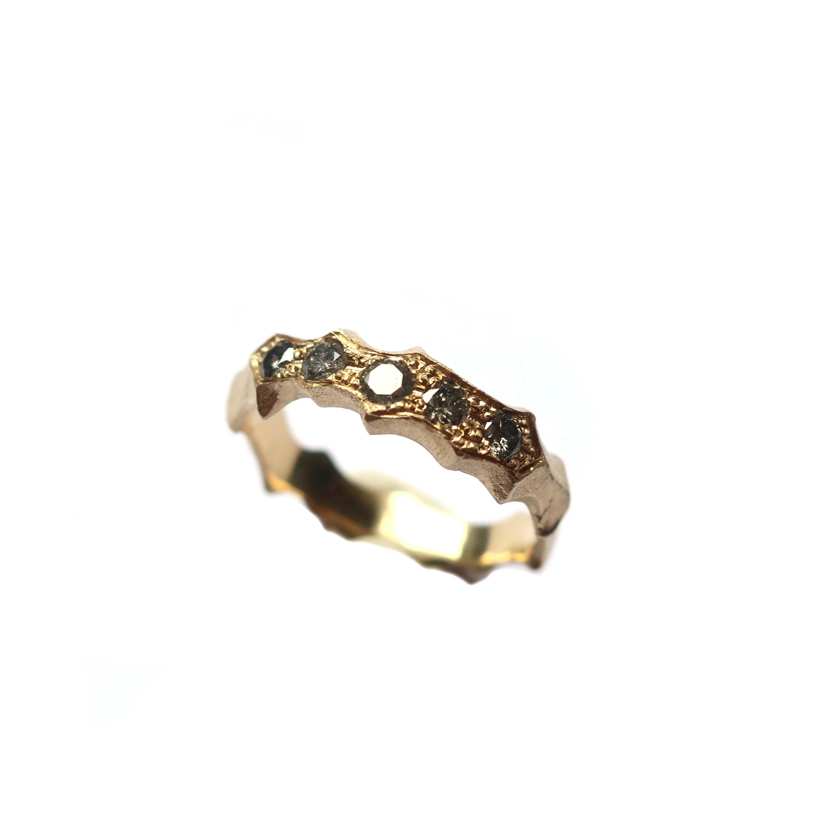 This hand carved unisex ring has 5 bead set salt and pepper diamonds in 14k gold. The band width is 3-4mm and 2.5-3mm thick. This is a wonderful alternative wedding band style. 

Instock sizes are - 8 and 6

Please message for alternative sizing,