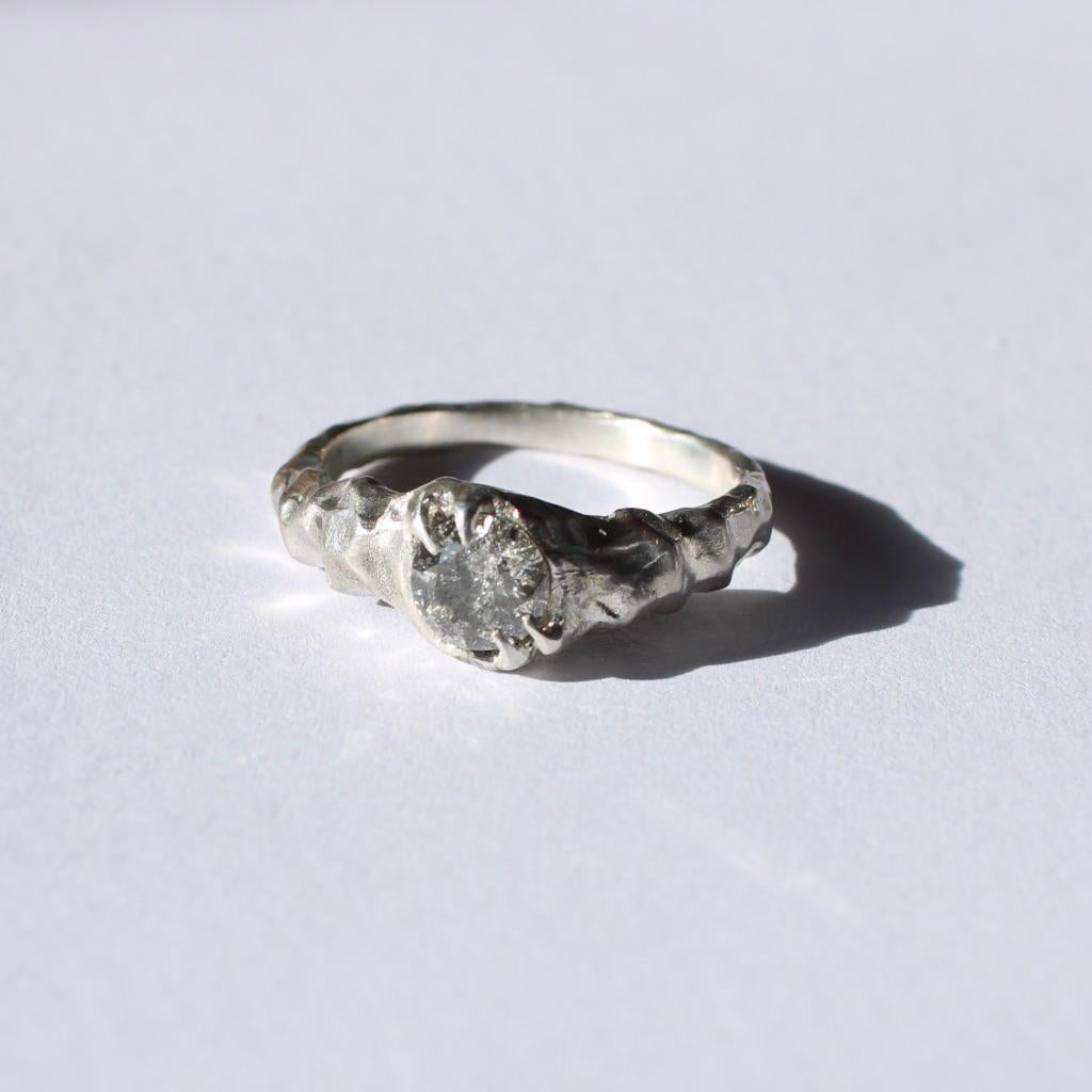 Solid 18k white gold ring with a ,62 carat 5,51 mm faceted diamond.  This piece is hand carved and features pointed offset prongs and a low profile. This unisex ring shows how beautiful gold as a sculptural material is. The shading created from the