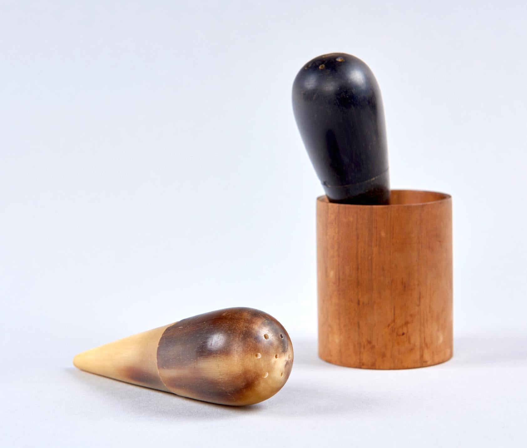 Two shakers, carved from horn, rest in a special turned walnut holder. A very playful way to supply condiments to your guests.

The shakers which are shaped like inverted drops, and feel very good in the hand are each made of two parts, which