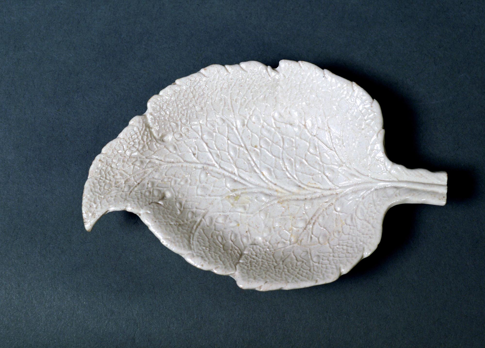 Salt-glazed stoneware sweetmeat dishes in the form of vine leaves,
a pair,
circa 1745-1765 
 
The Staffordshire salt glaze stoneware dishes are molded in the form of a vine leaf and are curved at the top of the leaf and with a straight stem at