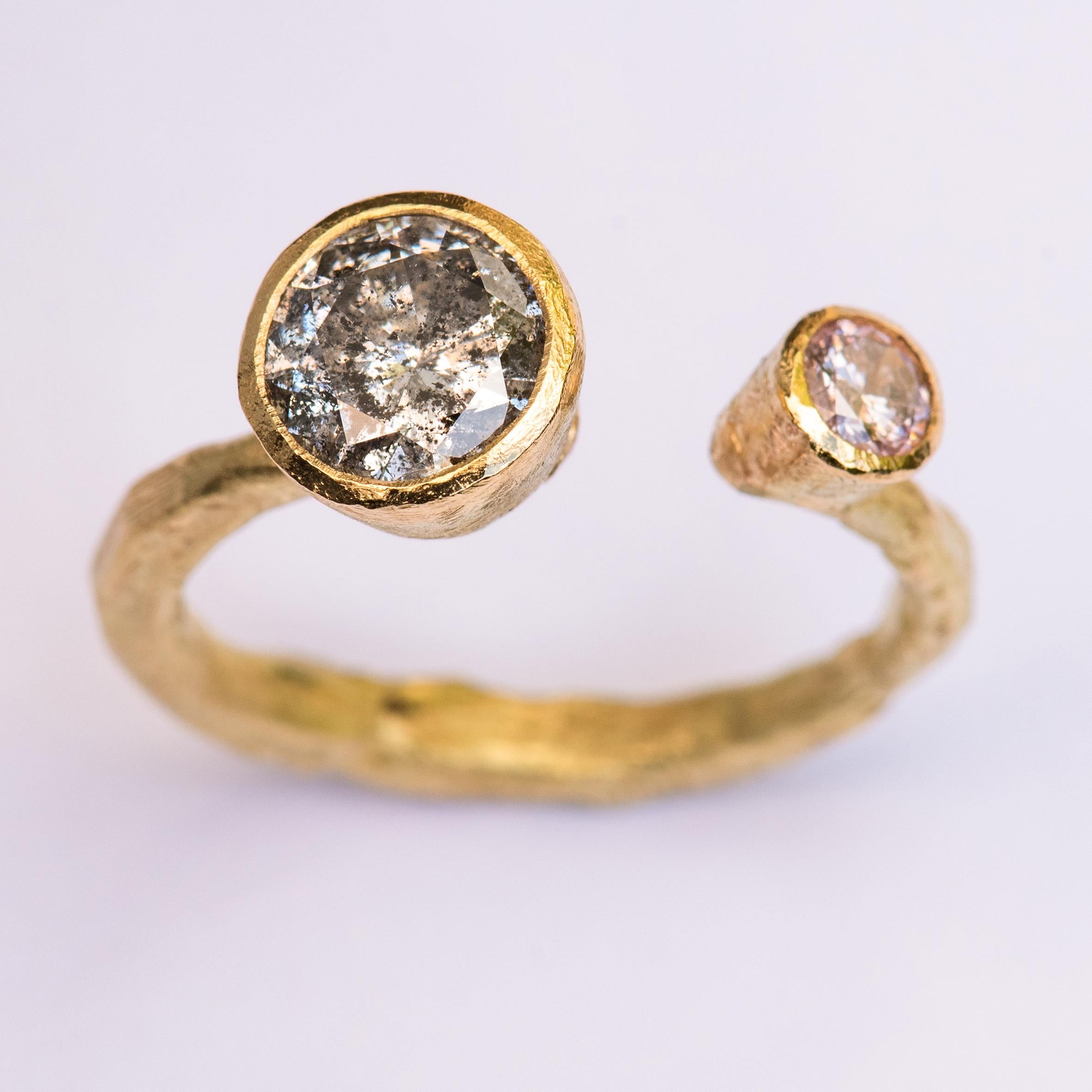 18k yellow gold organic textured open ring with large round 1.57ct salt and pepper grey diamond and 0.20ct pink diamond.
This open ring has been handmade by internationally renowned goldsmith Disa Allsopp. Disa is known for her textured metals and