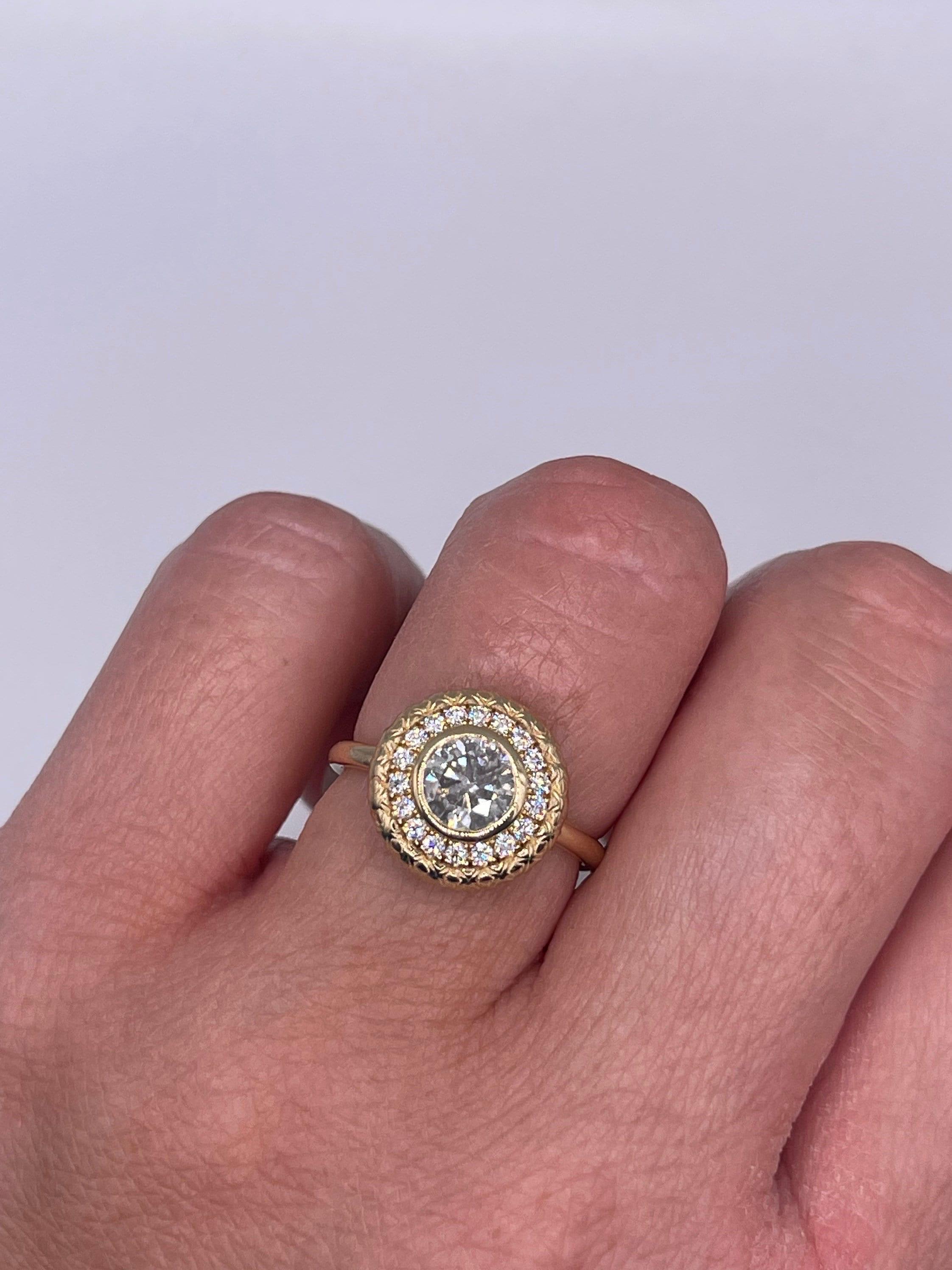 Precioso anillo, acabado a mano, impresionante dibujo grabado y un centro de 1 quilate de diamantes claridad I, color H. Diamantes laterales de 0,39 quilates de impresionante claridad VS-SI y color G. El anillo es de la talla 6 y se puede cambiar a