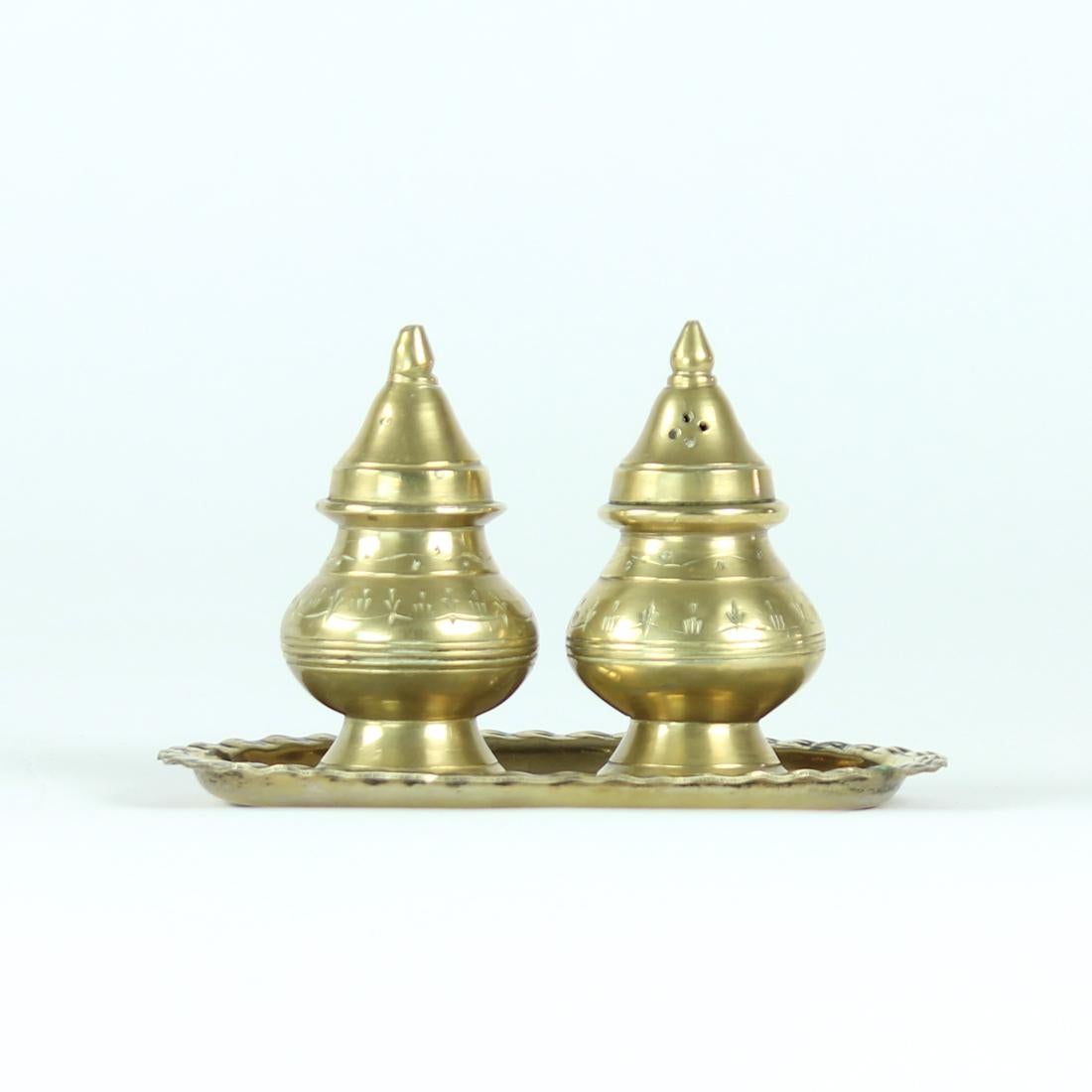 Beautiful set of oriental looking vintage salt and pepper shaker. Produced out of brass with oriental looking ornaments on each piece. The set stands on an original brass plate to finish the picture. Beautiful set in original, beautiful condition