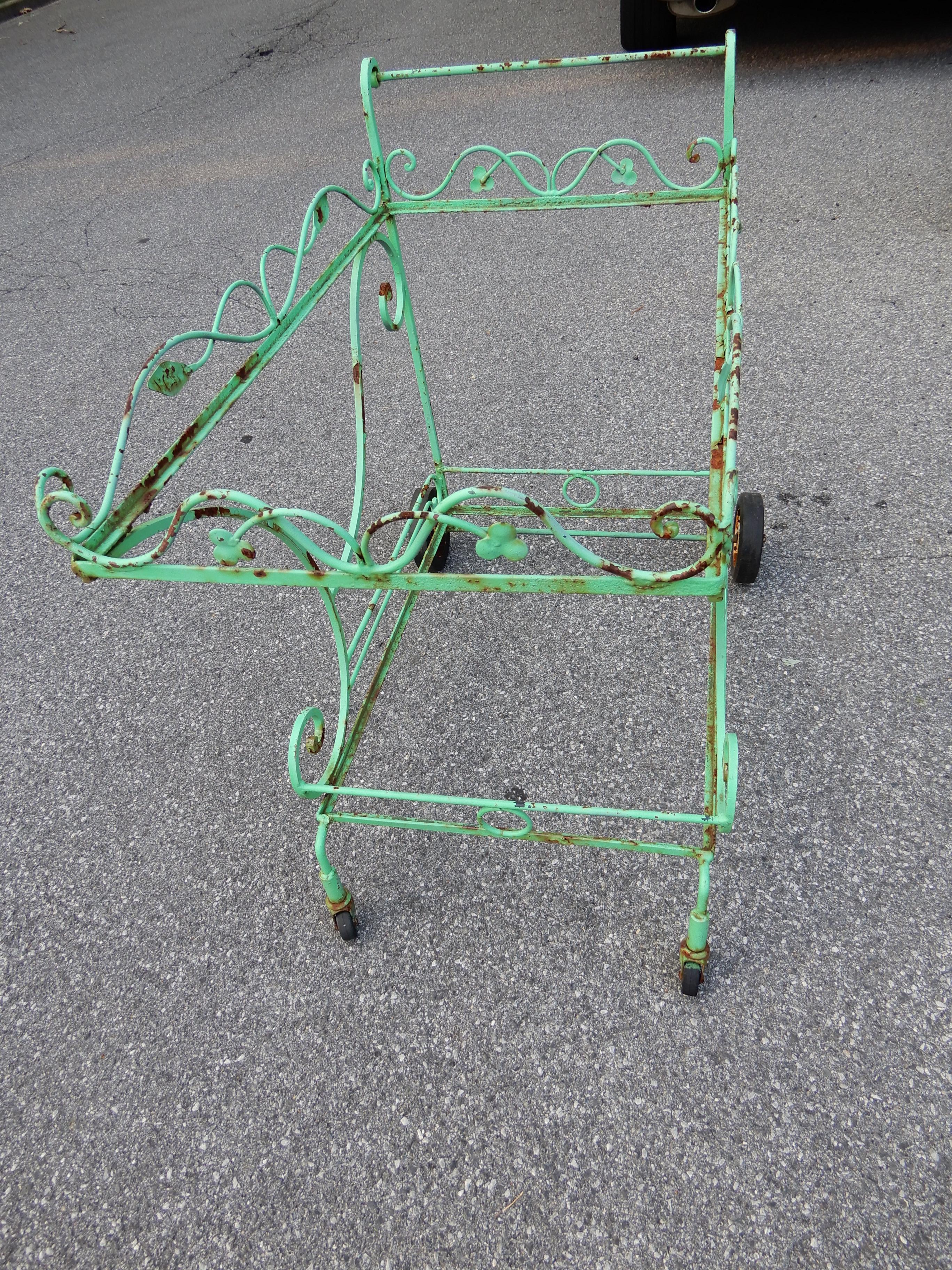 A wrought iron tea cart or bar cart by John Salterini New York mid 20th century. 
The cart has unfortunately been repainted in an awful green shade, it also is being sold without any glass. The Salterini cart was purchased with a Salterini dining