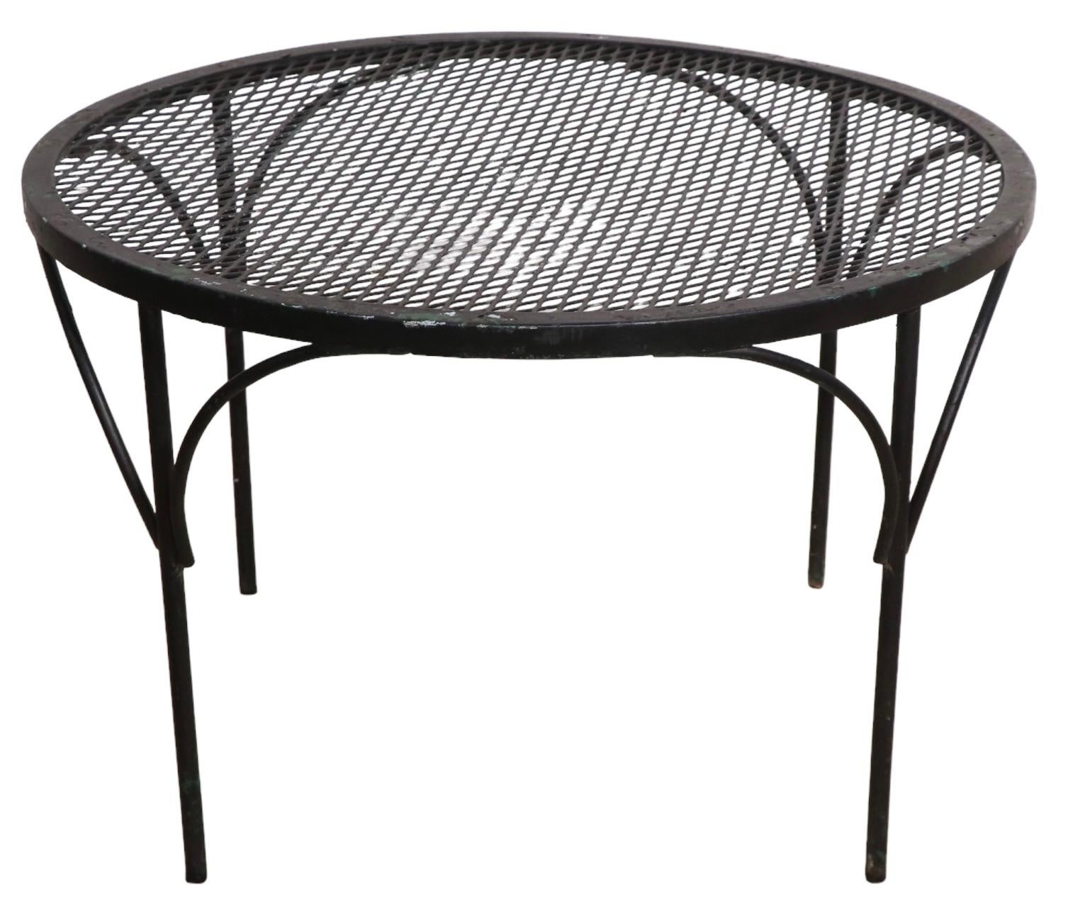 Chic architectural mid century coffee table of wrought iron and metal mesh, attributed to Salterini. This example is in very good, clean, and original condition, perfect for the garden, patio, or poolside use. 
 Please view our extensive collection