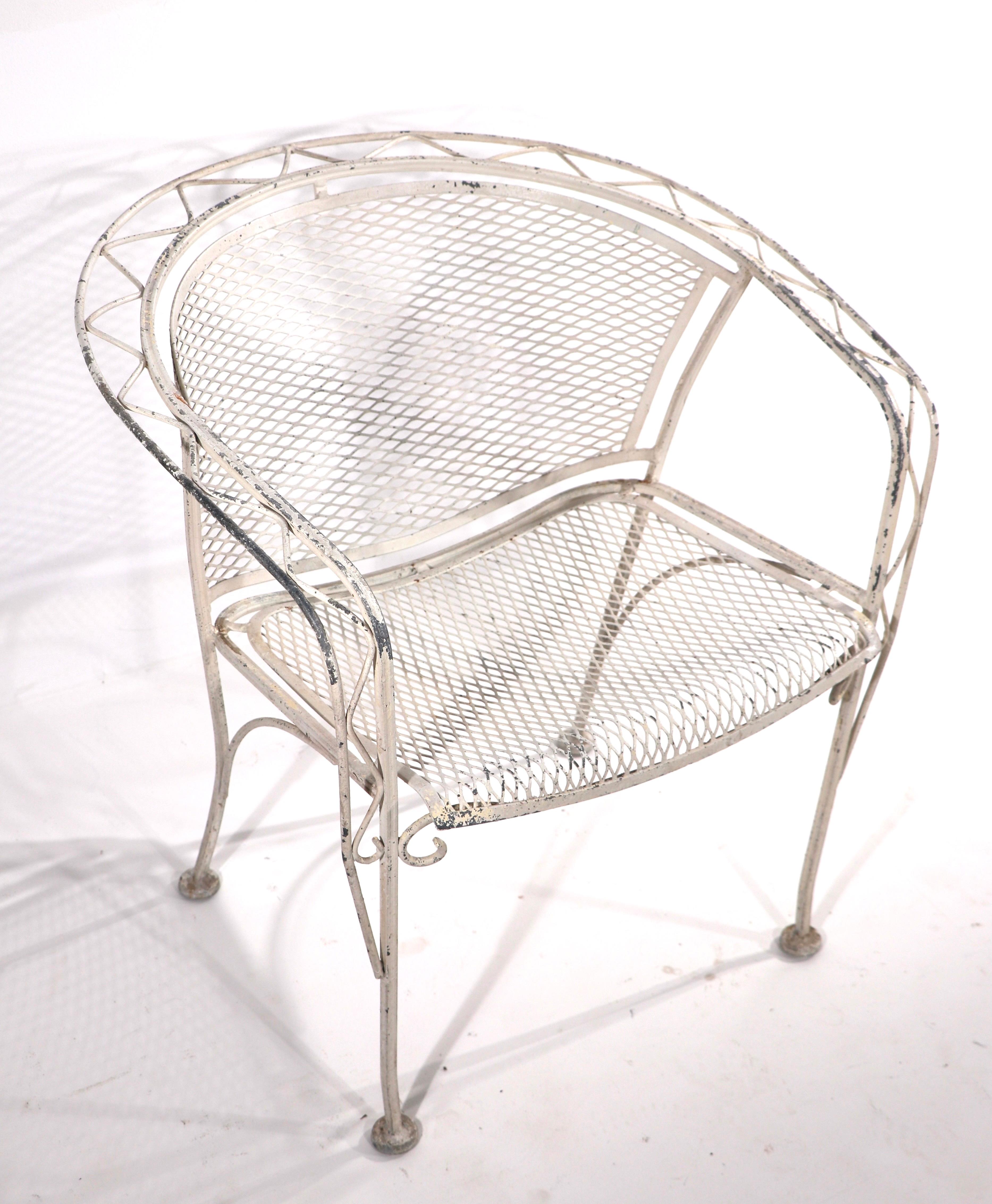Nice Salterini garden, patio, poolside chair having a wrought iron frame with zig zag metalwork pattern, and metal mesh seat and back. The chair is in very good, original condition, free of breaks, bends, damage or repairs. The paint finish shows