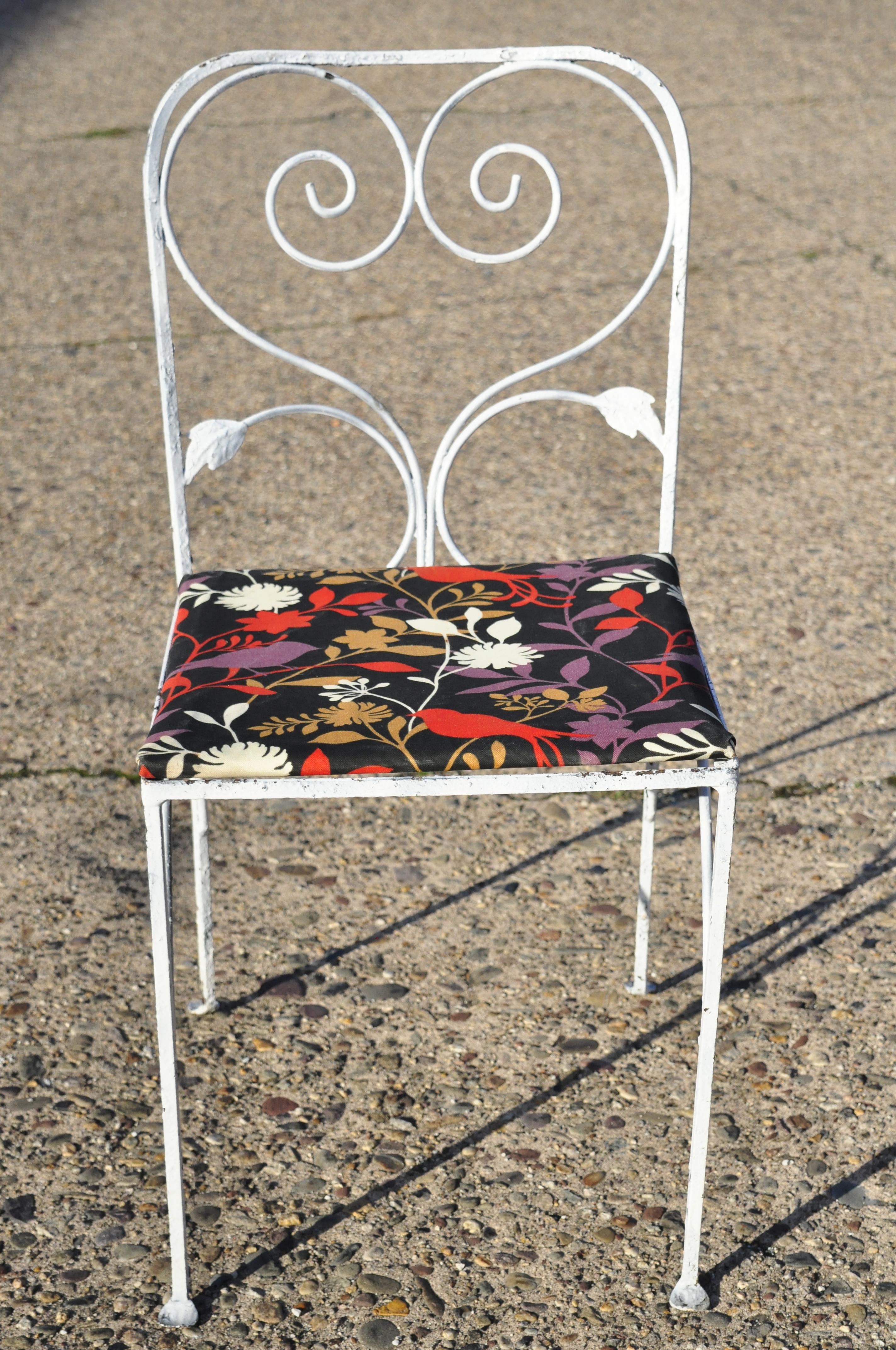 Vintage Salterini style leaf scroll wrought iron patio garden white dining chairs - set of 4. Set features (4) side chairs, red and black bird pattern fabric, leafy scrollwork backs, circa mid-20th century. Measurements: 32