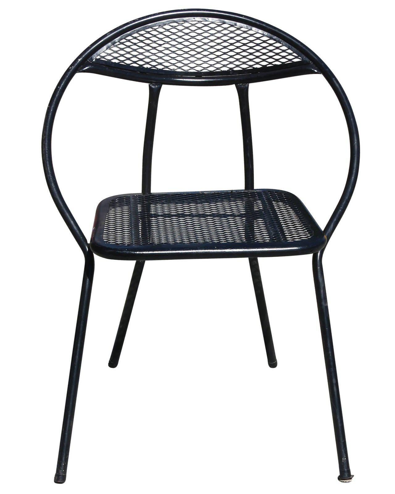 This Mid-Century Modern outdoor dining set by Salterini features four rounded-back, folding chairs and a square dining table with a hole in the center for an umbrella. The table and chairs are made of a combination of mesh and tubular steel all have