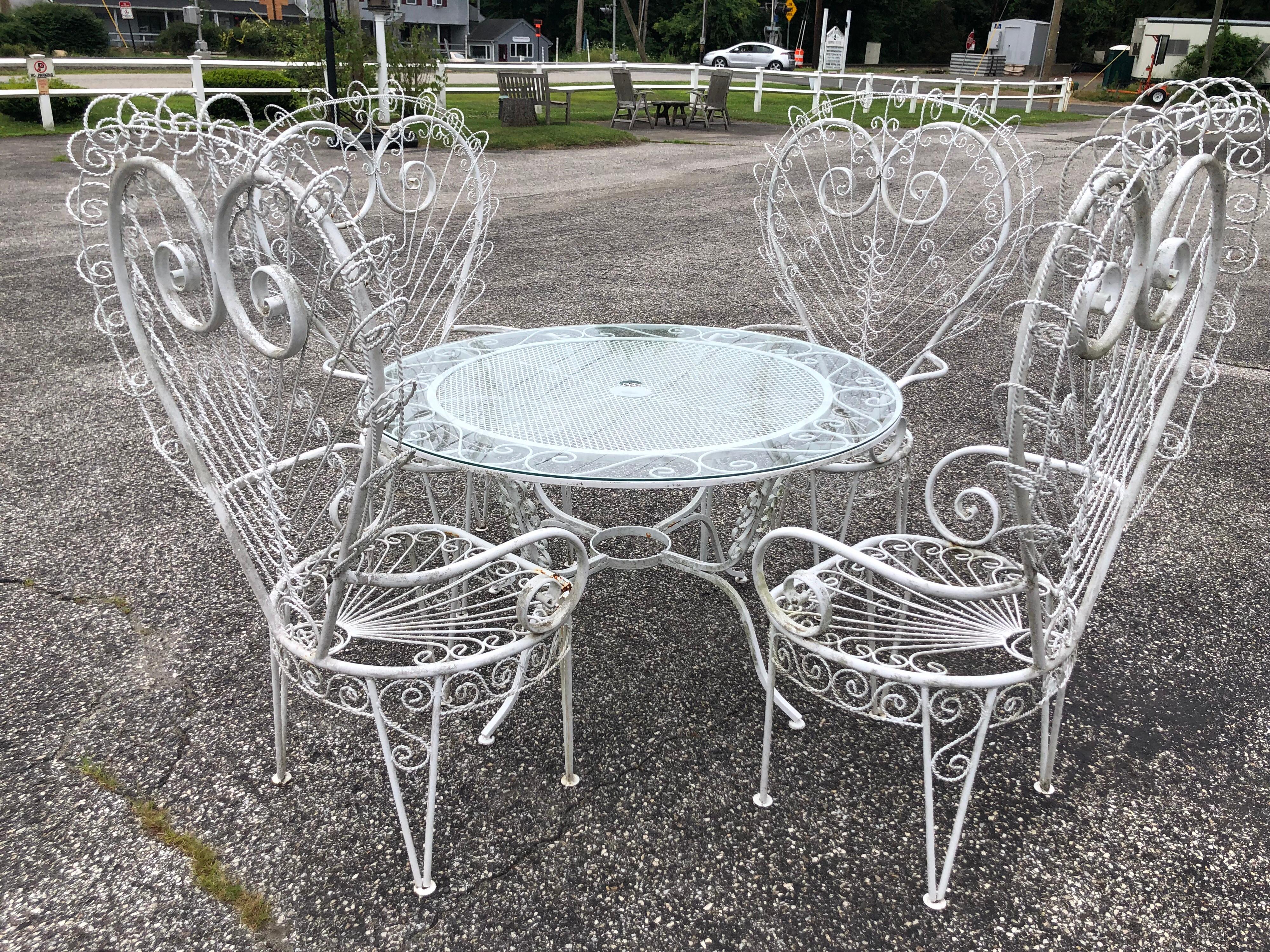 Salterini style white iron peacock Patio set. Fabulous Hollywood Regency style Patio set. Over the top glam or boho chic! Recently resprayed in white. Includes four chairs and table with custom cut glass with umbrella cutout. Table diameter is 48
