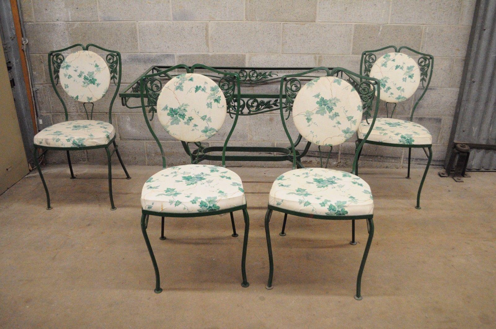Five-piece vintage wrought iron patio dining set attributed to Salterini - no glass. Item features four chairs, rectangular table (no glass), upholstered back and seats, floral vine pattern, green painted finish, shapely legs, high quality iron