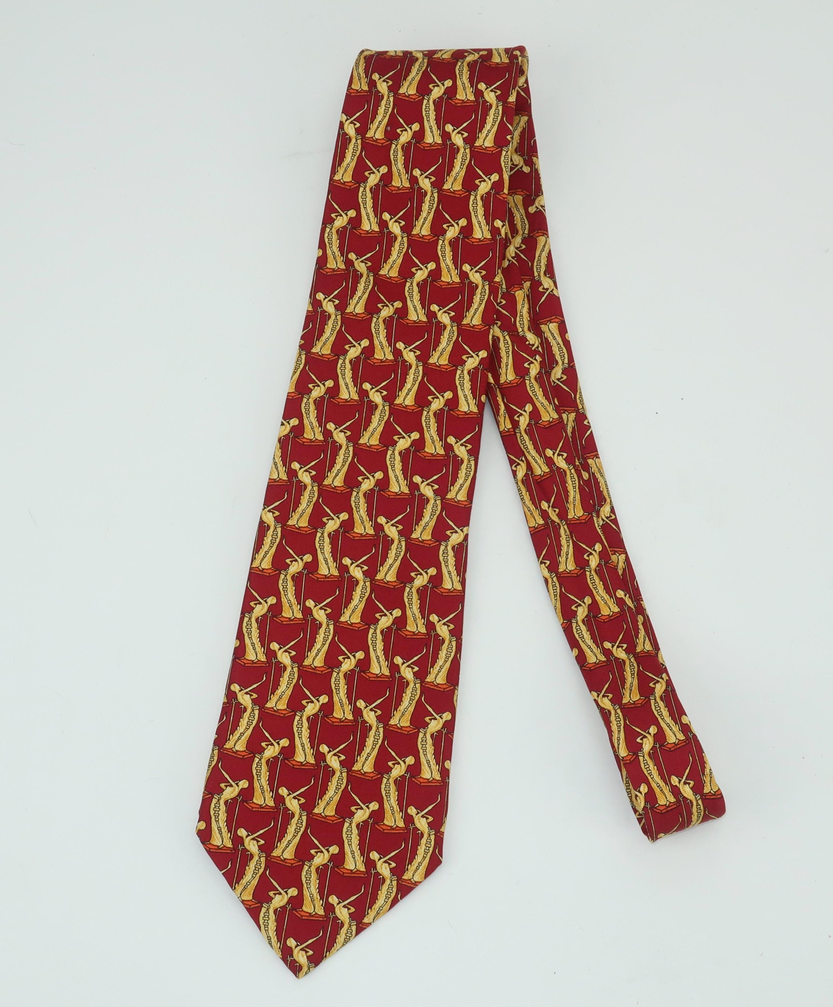 A 1980's Italian made silk necktie featuring the image of a C.1980 surrealist sculpture by Salvador Dali entitled 'La Femme En Flammes'.  The images are repeated in a pattern incorporating shades of brick red, buttery yellow with the hint of
