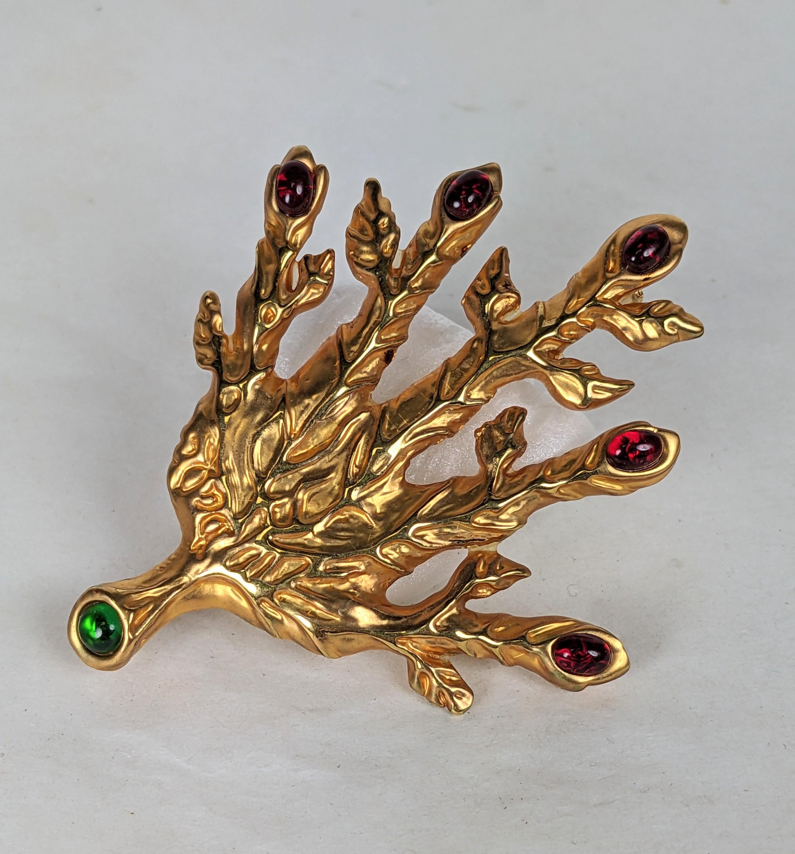 The Dali Leaf Veined Hand pendant brooch is ornamented with oval faux cabochon ruby nails and a round emerald faux cabocheon on the stem. Made of 18 karat yellow gold plate. Originally created in fine jewelry 1949, this brooch a 2001 re-edition.