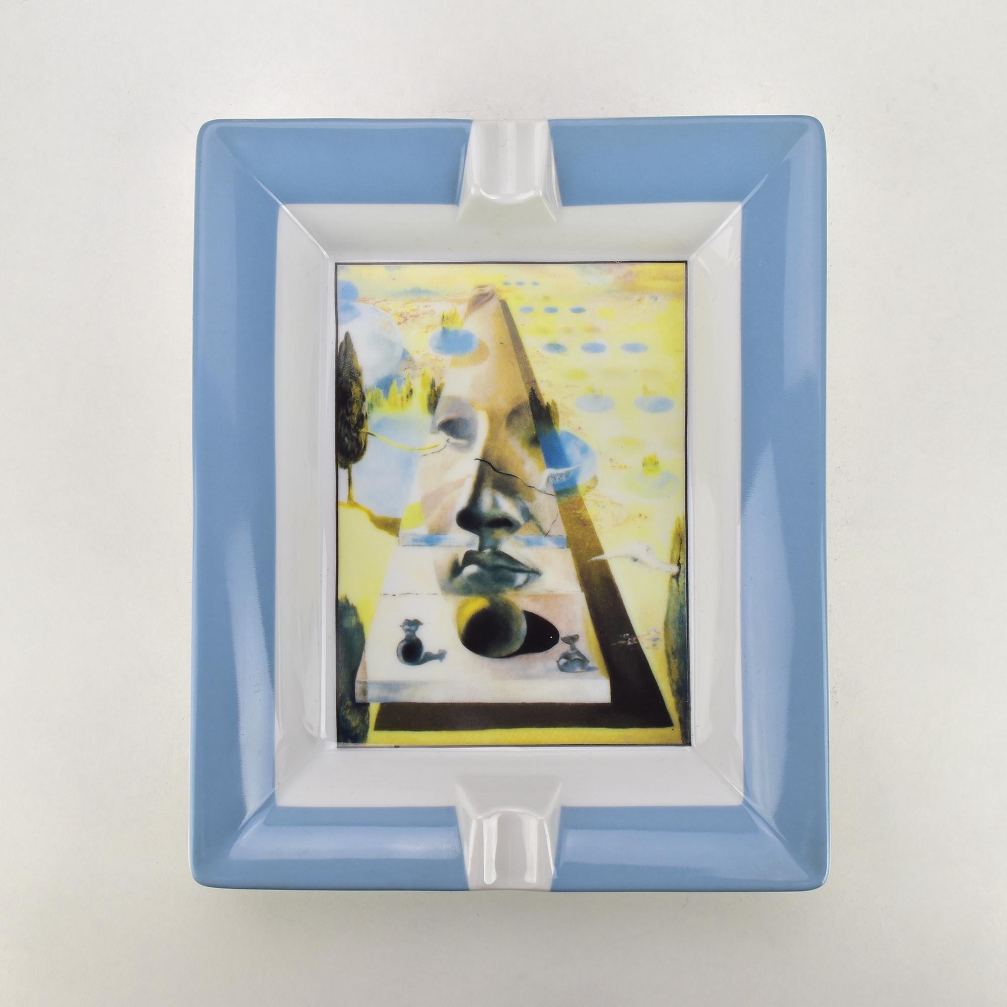 Dieser exquisite, von Limoges hergestellte Porzellan-Aschenbecher zeigt ein ikonisches Kunstwerk von Salvador Dalí, das detailgetreu reproduziert wurde. Das Werk, das das surrealistische Genie von Dalí hervorhebt, zeigt 