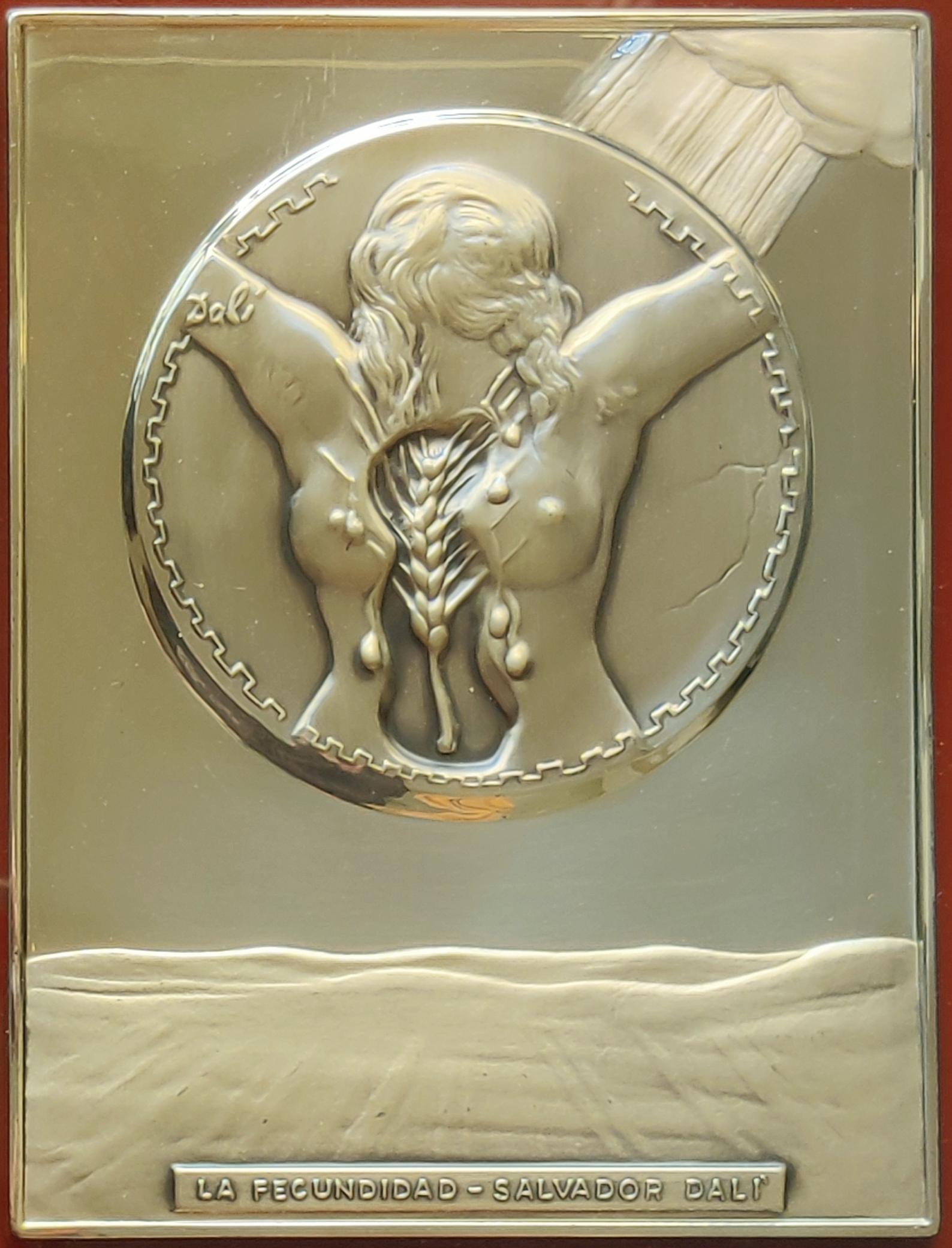 Salvador Dali 
Fecundity - Bas Relief Silver Sculpture, 1977
Dimensions: 24 x 18 cm
Framed: 38 x 33 cm
Signed on the bas relief and printed signature on the certificate on the back.
Edition number: I/564
This limited edition plaque was mounted to