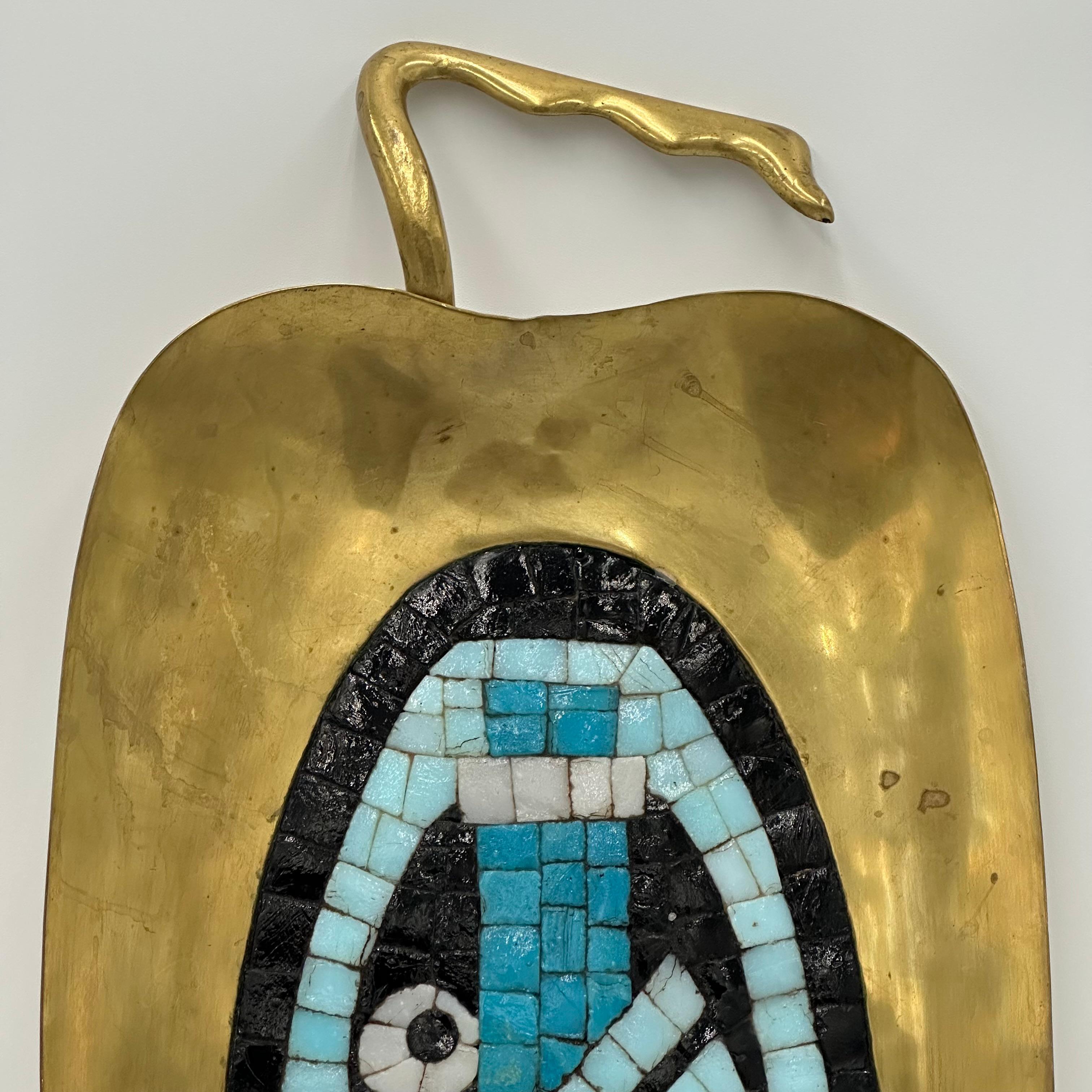 This very collectible tray by Salvador Teran, Los Castillo, Taxco, Mexico, was created in the 1950s-1960s. The mosaic design is composed of variegated blue, white, and black glass tiles, which have been set into a hand-wrought brass tray. This