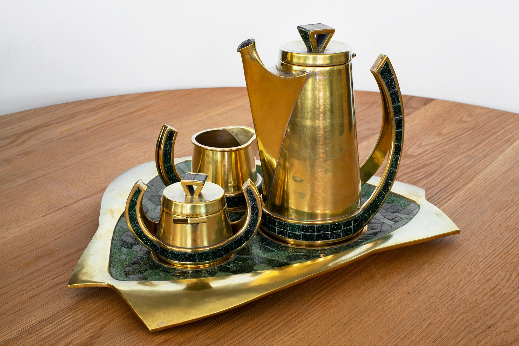 1960s handmade brass tea or coffee set by Salvador Teran. 
Intricately crafted with dark glass mosaic design inlay.

Set includes:
1 coffee pot 
1 ccream jug 
1 covered sugar bowl with spoon 
1 tray 

 2 sets available.