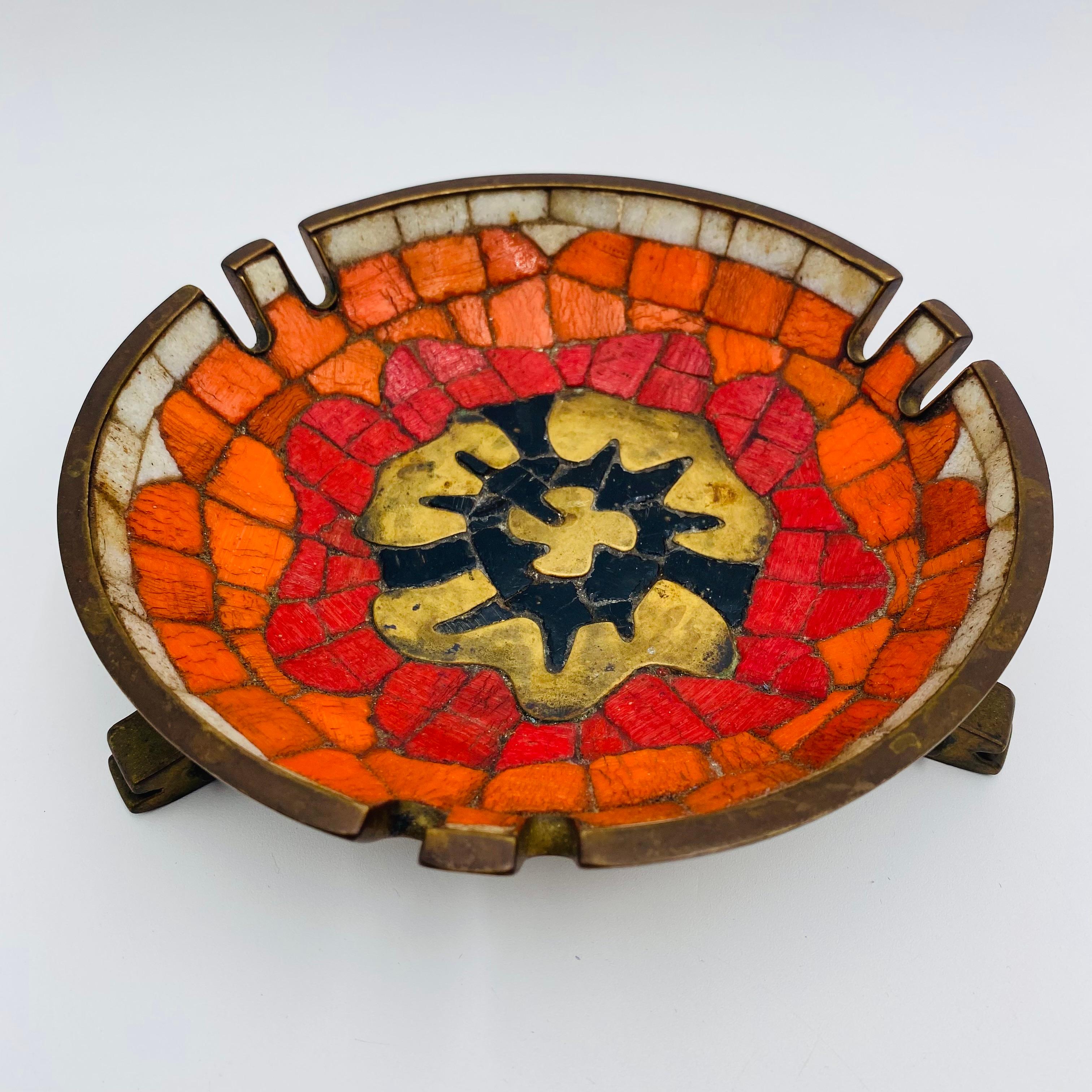 Brilliant orange, red, white, and black cut tiles with poured brass create a flower-centric look in this 1950s Salvador Teran mosaic and brass ashtray. It is truly a Mexican design and useful for its original intention as an ashtray or as a catchall