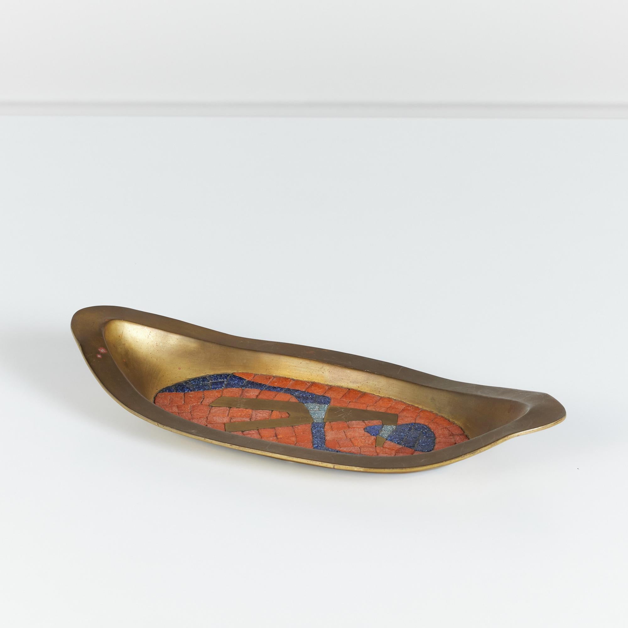 Oval handwrought brass dish in the style of Salvador Teran, circa 1950s Mexico. The tray features a square orange and blue speckled tile mosaic inlay that resembles a figure.

Dimensions
15