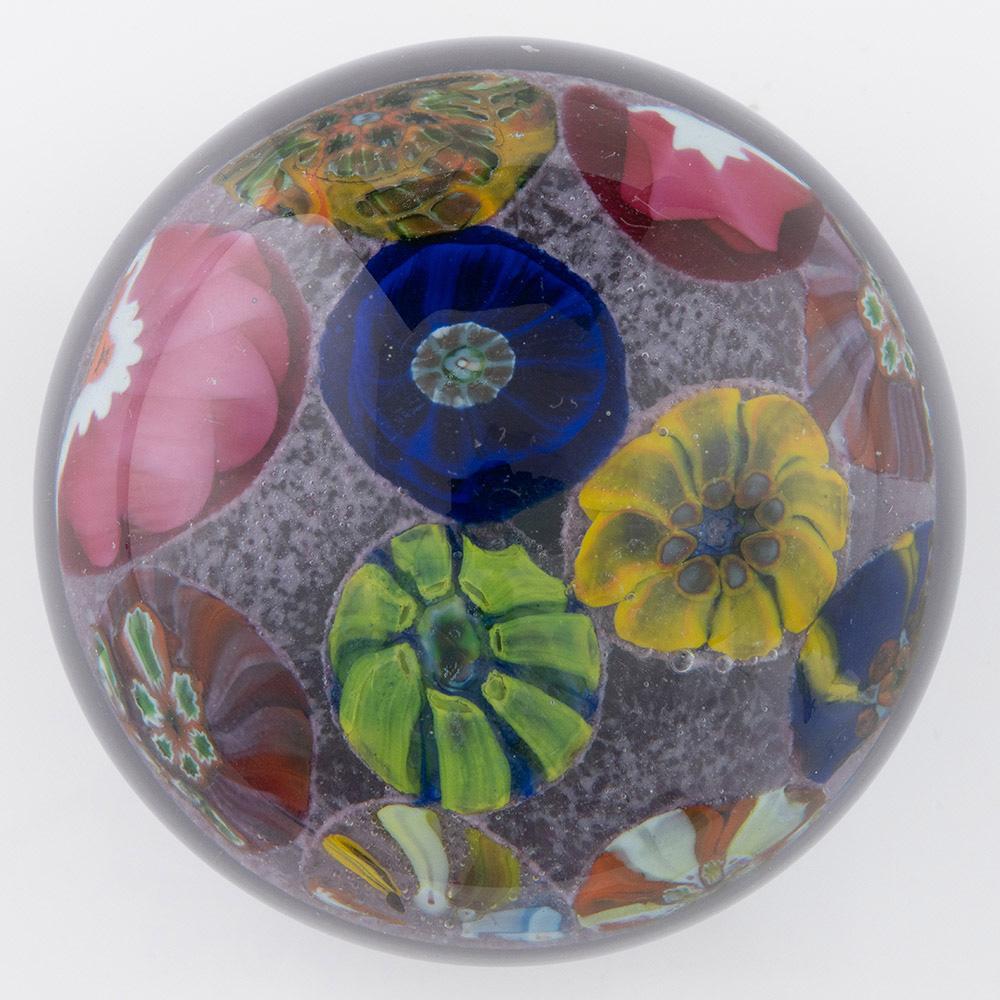 Überschrift : Salvador Ysart Briefbeschwerer Raum Millefiori um 1950
Datum : um 1950
Herkunft: Schottland
Merkmale: Große konzentrische Millefiori-Canes in einer zweireihigen konzentrischen Anordnung auf  fliederfarbener Boden. Eine violette Färbung