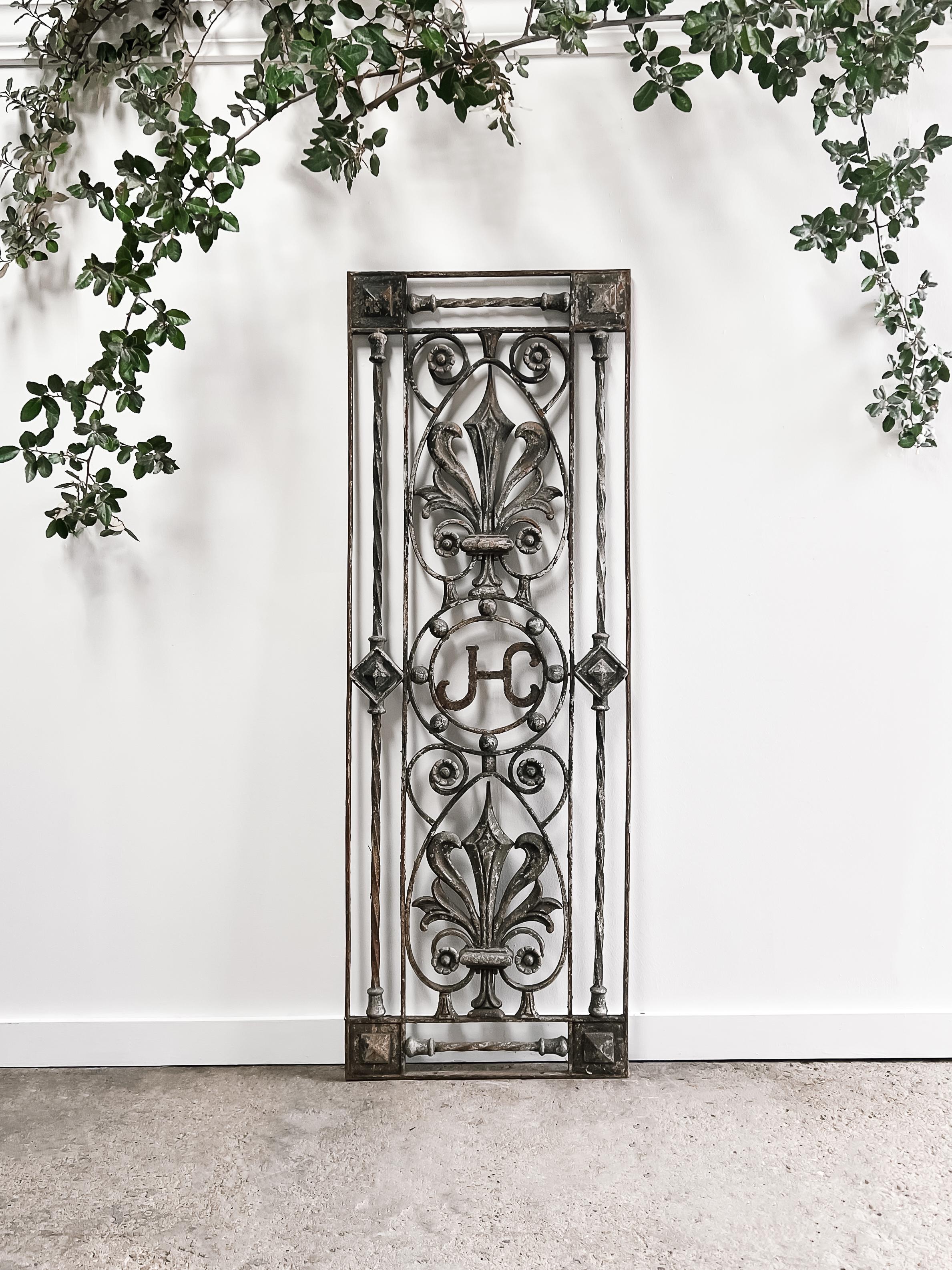 A wonderful substantial and heavy decorative cast iron gate panel found in France. The panel has a great time-worn patina and features a decorative fleur de lis and floral design. Nestled within the center of the panel rests the monogram “JC” or