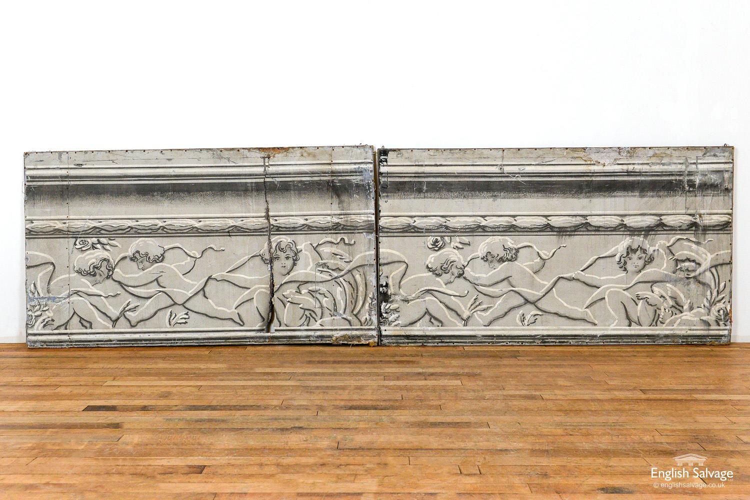 Two painted architectural canvases portraying a plasterwork frieze depicting cherubs. Overall size below, each canvas is 150cm wide. One canvas has a rip as highlighted in the photos, both have some wear and smudging to black paint work.
