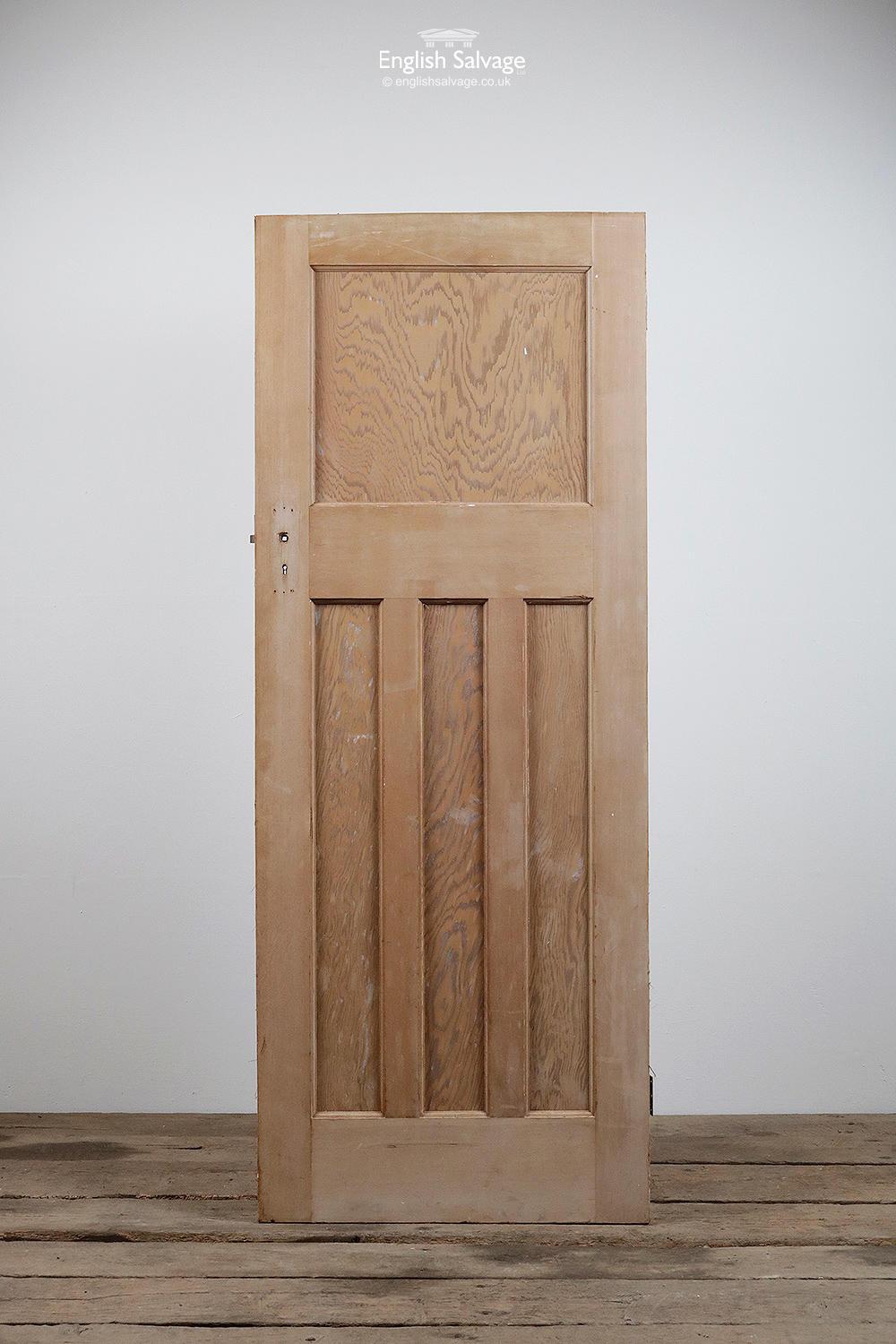 Salvaged stripped pine one over three panel interior door with two hinges. Uneven top, slightly rough finish from paint stripping, plus lock, handle and nail holes.