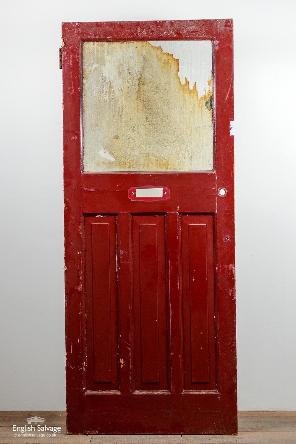 Old door with a large textured glass panel above three vertical panels. Letter plate, handle, lock and nail holes plus some chips present.