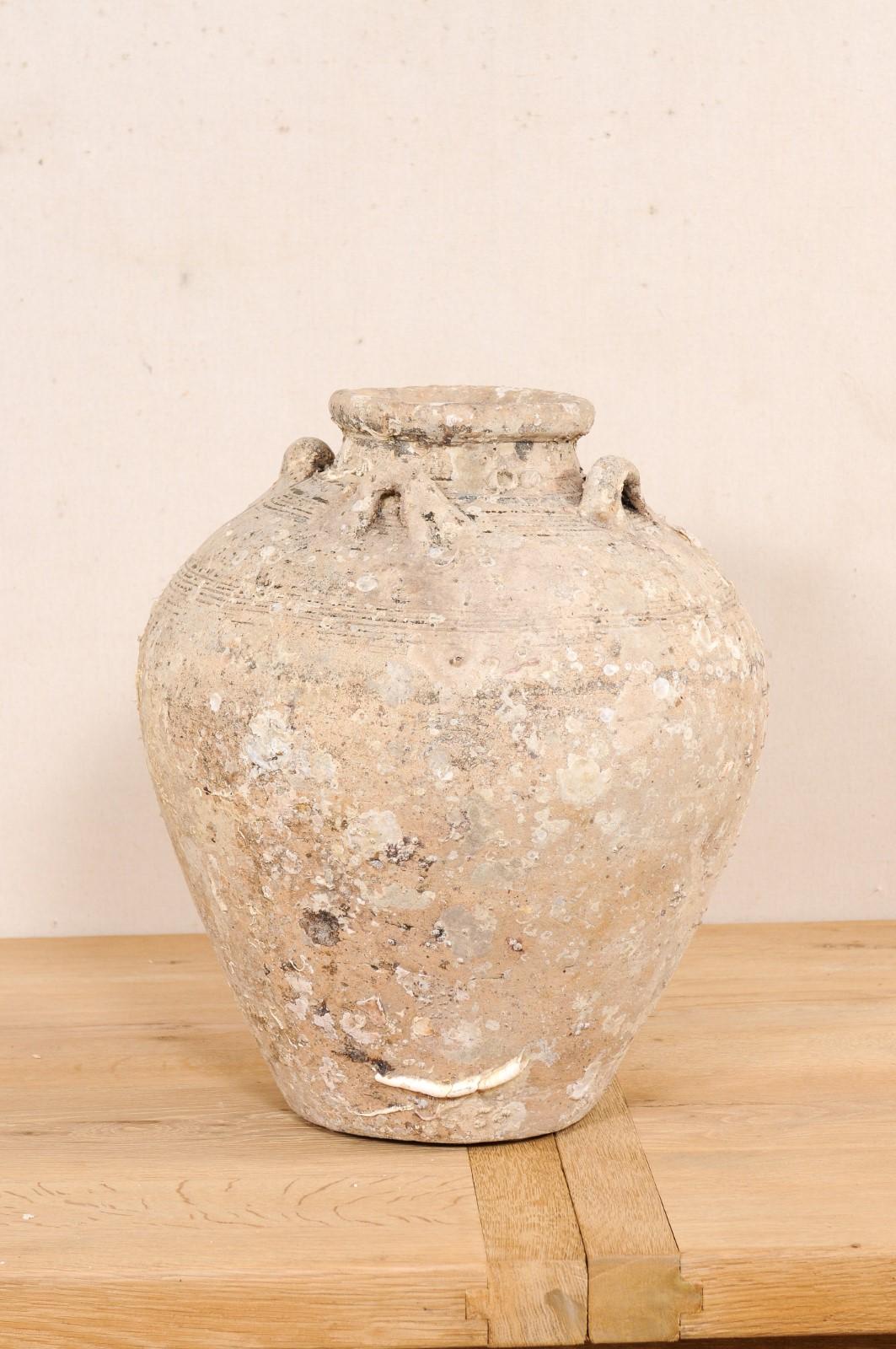 This ceramic vessel from Thailand, circa early to mid 1500's, is an excellent specimen of a salvaged ceramic jar from a shipwreck during in the Ming gap period. This antique jar from Thailand stands just over 20 inches in height and has a rounded