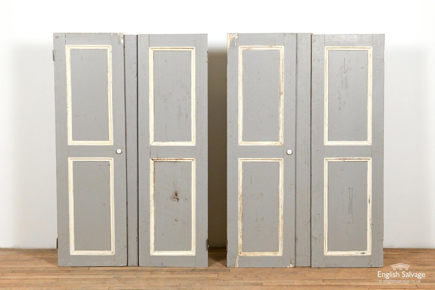 Salvaged pine cupboard doors. Painted grey with fielding picked out in off-white, and complete with ceramic knobs. Some scratches and surfaces knocks and dinks commensurate with age and use. Some have add-ons as they have been fitted in an old