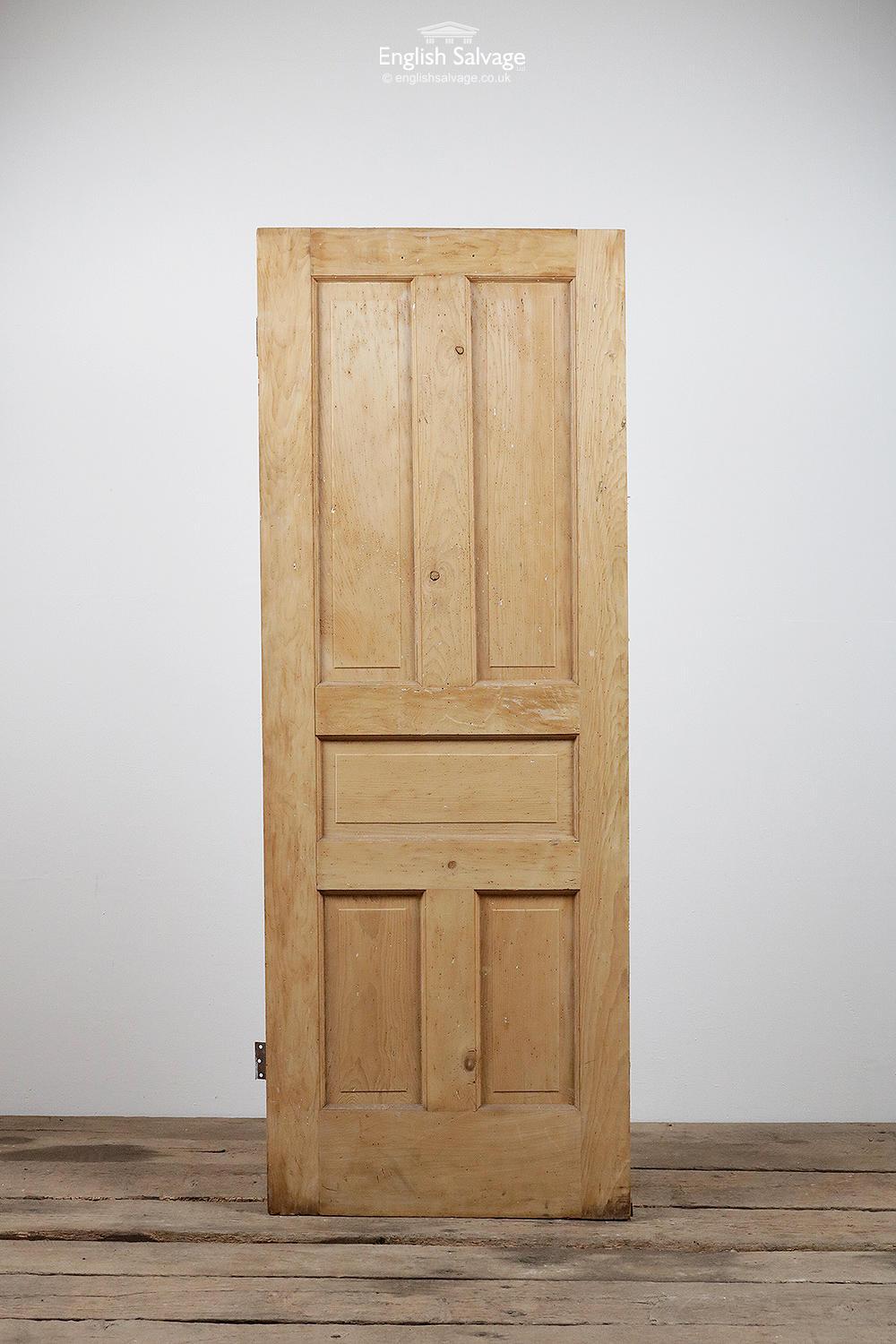 Salvaged stripped pine door with five raised panels and two hinges. Dings to a few panels plus lots of small holes to one side of the door (looks like a dart board was hung on the door).