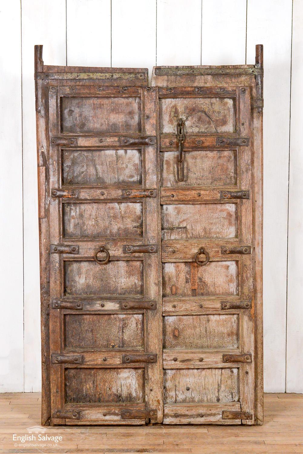 Old Indian salvaged pair of doors/panel. The doors are bared together on the back to make a single panel. These bars can be easily removed. Lovely old metal work remains on the doors. Scrapes, splits, repairs commensurate with age.