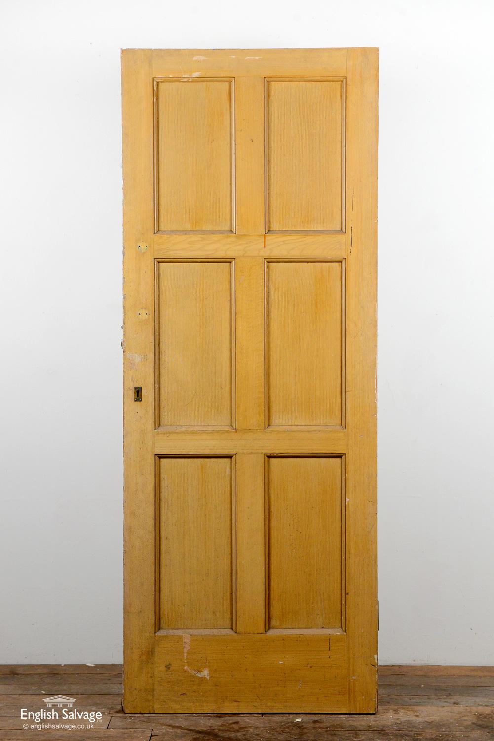 Old door which has six panels to one side and has been boarded over on the other. Two hinges plus, lock, handle and nail holes present. Dings to edges, especially to the bottom of the boarded side of the door.
