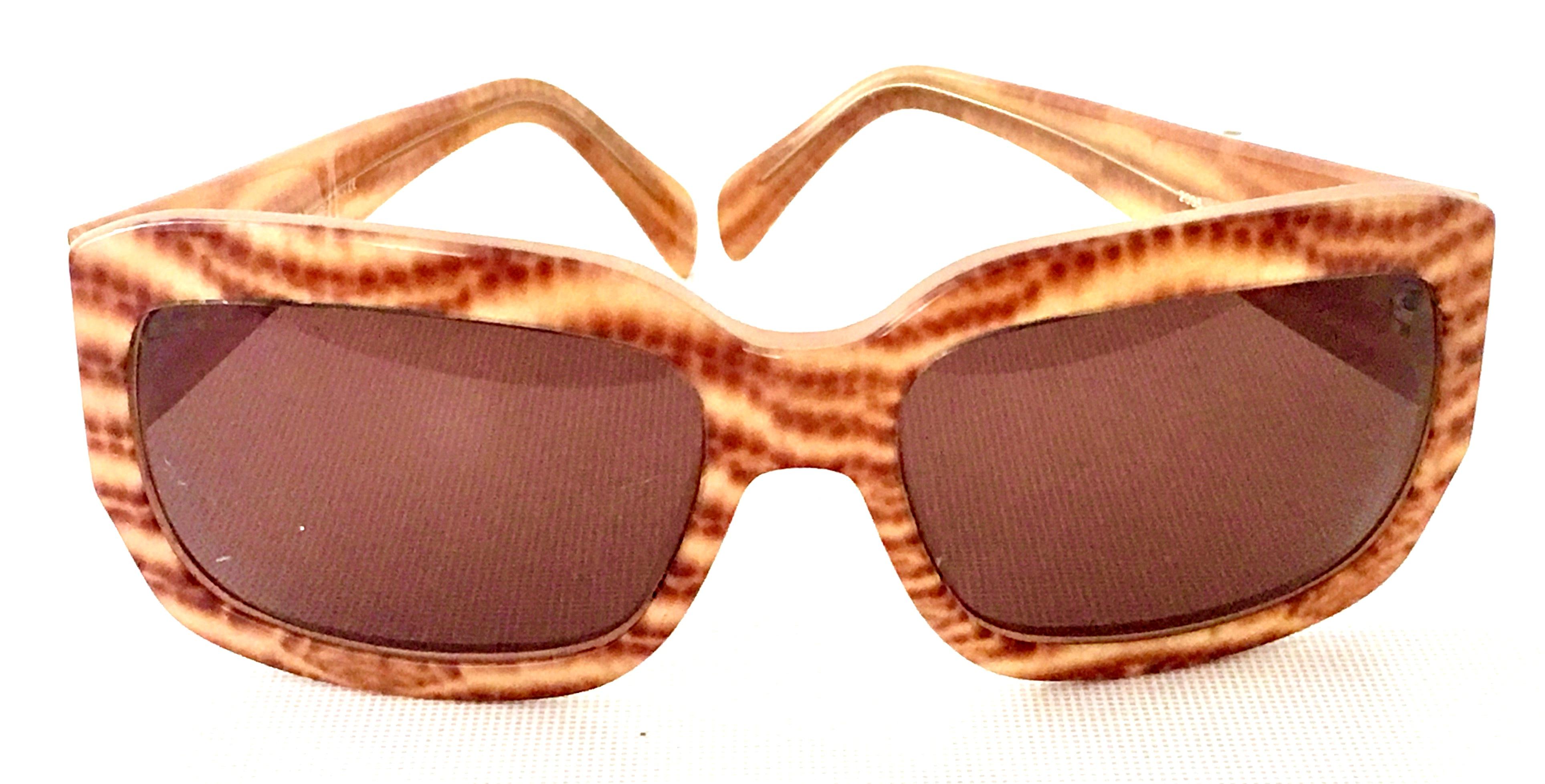 Salvatore Ferragamo abstract animal print sunglasses. Features a subtle amethyst tinted lens with shades of brown frames. Signed Salvatore Ferragamo, Made In Italy. #2035 239/63. Includes original red Salvatore Ferragamo protective carrying