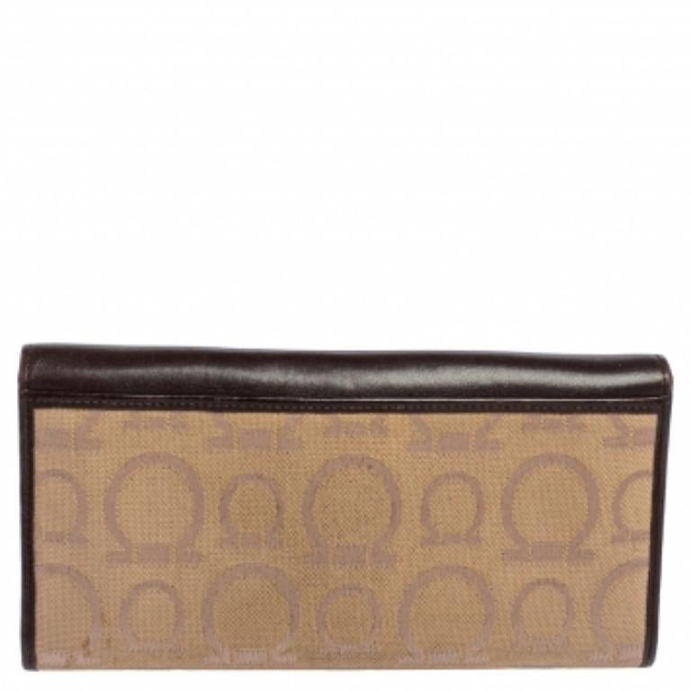 Cette création élégante de Salvatore Ferragamo est sans aucun doute le choix d'une fashionista ! Confectionné en toile enduite Gancini et en cuir de haute qualité, ce portefeuille est doté d'un rabat portant le logo de la marque. Il est doté de