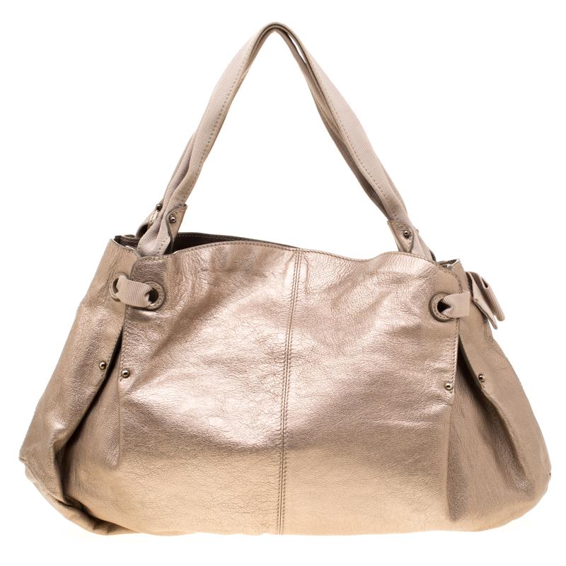 Diese Salvatore Ferragamo Hobo Bag hat eine lässige Form und ist in Beige gehalten. Die Tasche ist aus Leder gefertigt und mit einer Schleife, zwei Henkeln und einem geräumigen Innenraum aus Canvas für Ihre wichtigsten Utensilien ausgestattet. Er