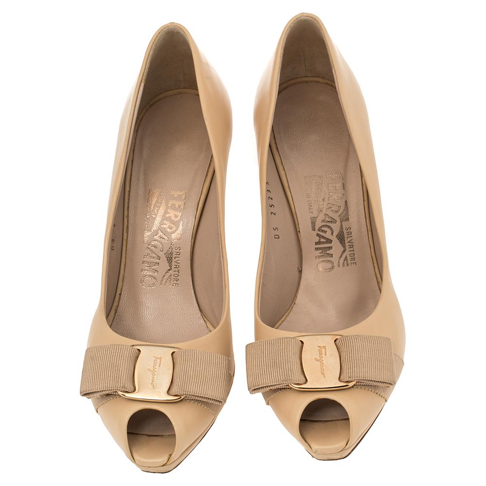 An iconic shoe design from the House of Salvatore Ferragamo, the Vara Bow pumps are absolute must-haves. These in beige are crafted using leather and designed with peep toes, signature bows, platforms, and 9.5 cm heels.

