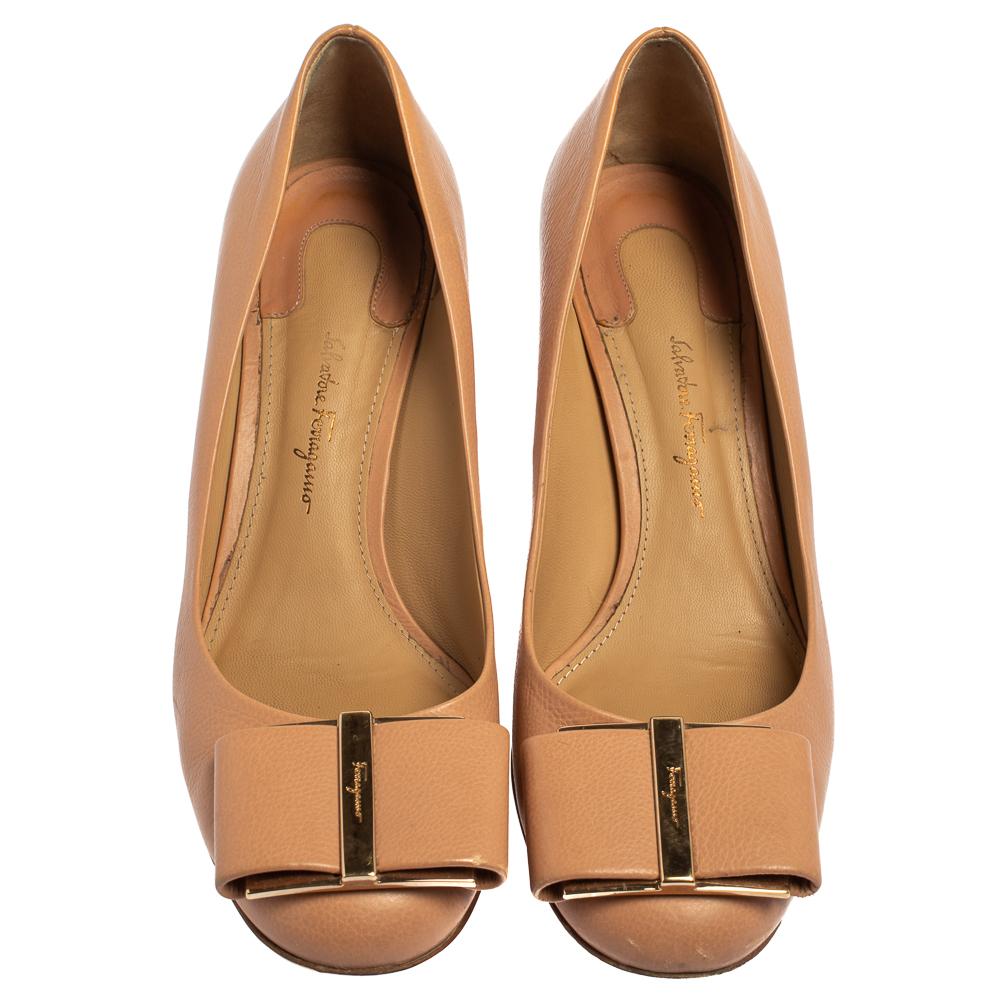 Made from good quality leather, this pair of Varina pumps will add a classic touch to your collection of heels. Designed with the signature bow details on the uppers and elevated on 6 cm block heels, this beige pair by Salvatore Ferragamo is the
