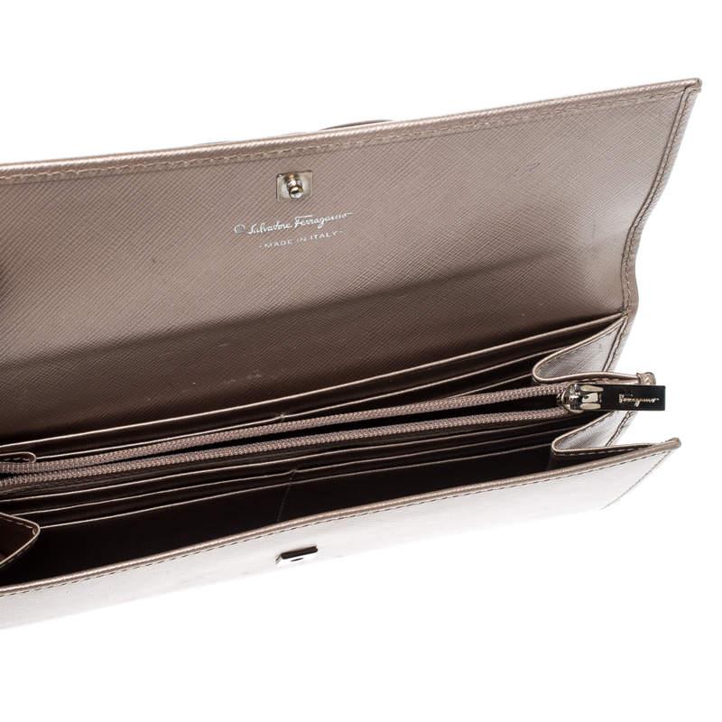 Crafted from leather, this metallic beige Salvatore Ferragamo wallet has a lovely style. It has been designed with a flap that reveals an interior of slots and a zip compartment. The sweet bow on the front adds to its beauty and makes it a worthy