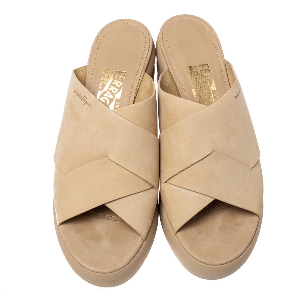 Stand out and make a statement while wearing this stunning pair of Salvatore Ferragamo sandals. Constructed from nubuck in a beige hue, they feature broad straps and comfortable insoles. The stacked-look of the wedges gives a dramatic look to your