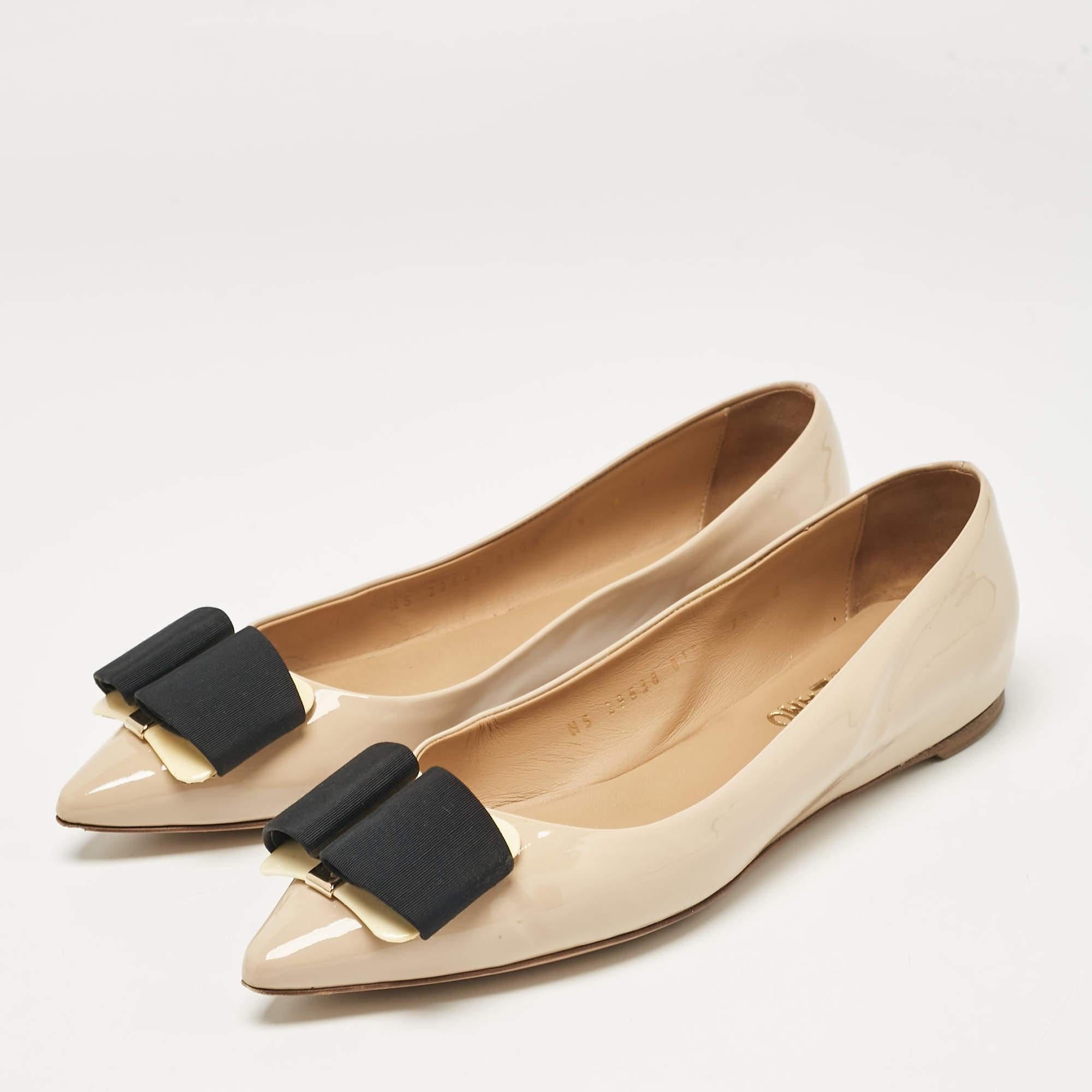 Queste ballerine di Salvatore Ferragamo sono comode e chic e possono essere abbinate a tutto, da un abito a camicia ai jeans skinny. Realizzata in pelle verniciata beige  sono completi di archi sulla tomaia.