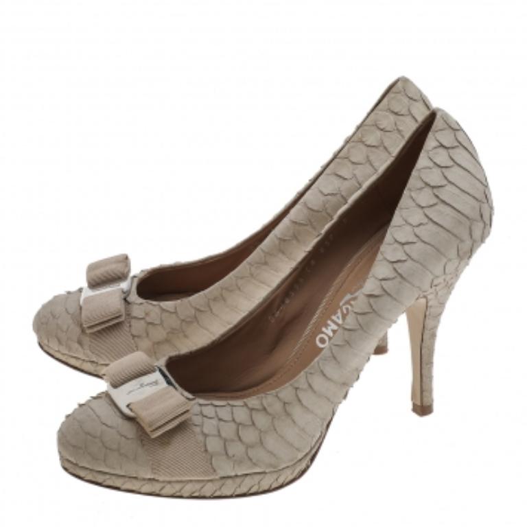 Diese Salvatore Ferragamo Pumps sind aus auffälligem und luxuriösem Python gefertigt und werden auf Partys und bei besonderen Anlässen garantiert auffallen. Die runde Schuhspitze und die mit einem silberfarbenen Medaillon verbundene Schleife auf dem