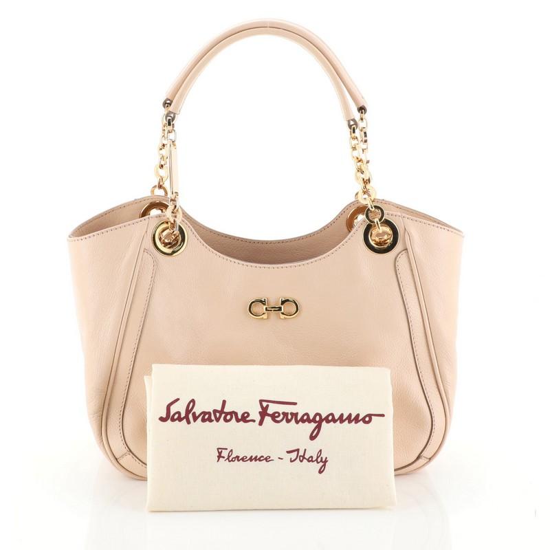 This Salvatore Ferragamo Betulla Chain Tote Leather Small, crafted from neutral leather, features chain shoulder straps with leather pads, signature Salvatore Ferragamo Gancini logo on front and gold-tone hardware. Its wide top opens to a neutral