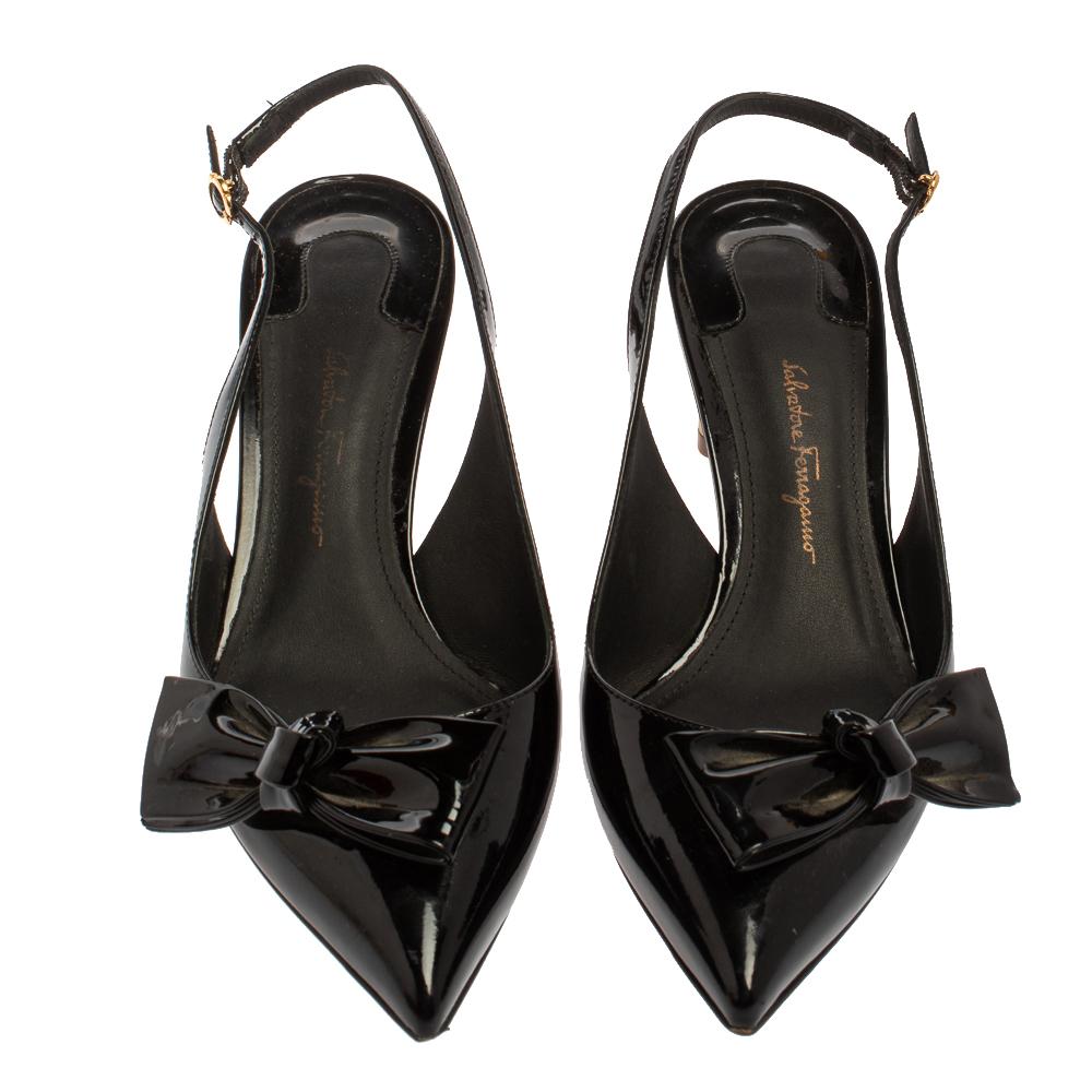 Endless compliments will come your way every time you wear these Salvatore Ferragamo sandals. The black sandals are crafted from patent leather and styled with pointed toes, trendy bow details on the uppers, and slingbacks. They are complete with