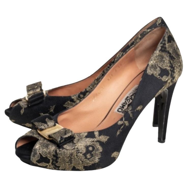 Epitomizing class and style, these Salvatore Ferragamo pumps will add a royal look to your overall ensemble. Crafted from brocade fabric into a peep-toe silhouette, these pumps are adorned with bows on the uppers and set on 10.5 cm heels.