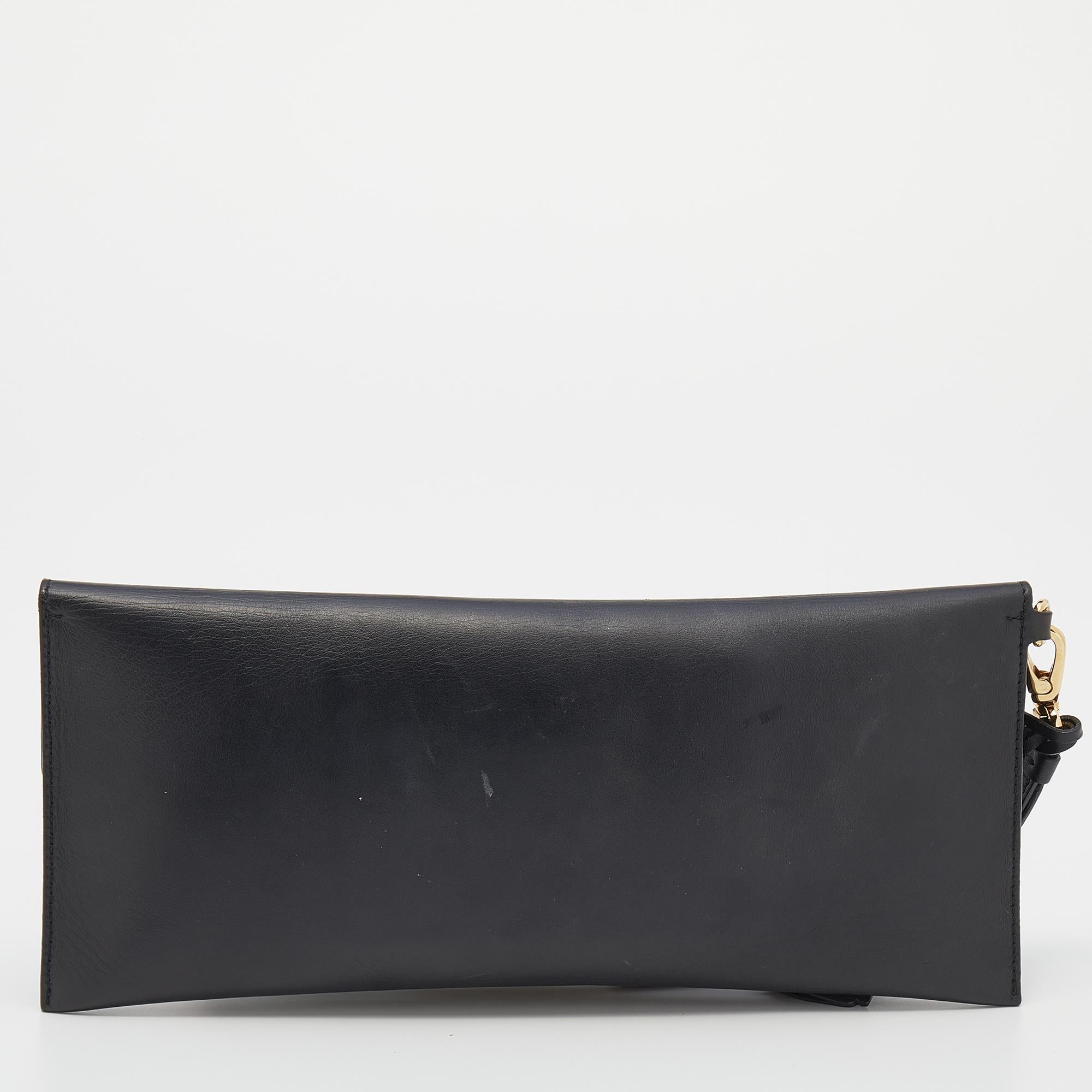 Coming from the House of Salvatore Ferragamo, this 'Afef Lock Story' clutch is all about flaunting luxury and perfection! It is crafted using black leather on the exterior and exhibits a leather-lined interior and gold-tone hardware. Elevate the