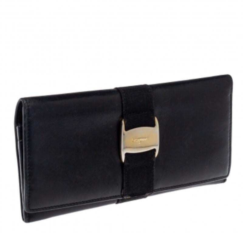 Made of black leather, this wallet from Salvatore Ferragamo is a classy choice. The flap opens elegantly to an interior with multiple card slots and a zipped pocket. This wallet is complete with the signature bow on the front.