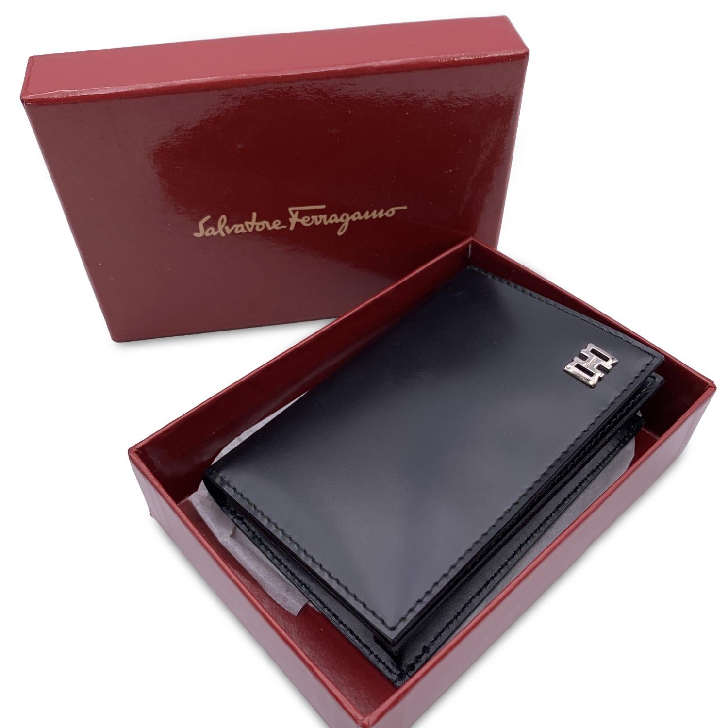 Salvatore Ferragamo black leather card case with keyring. Silver metal hardware. Button closure. Inside it has 5 open pockets and 1 zip coin section. 'Salvatore Ferragamo - Made in Italy' embossed inside.

Details

MATERIAL: Leather

COLOR: